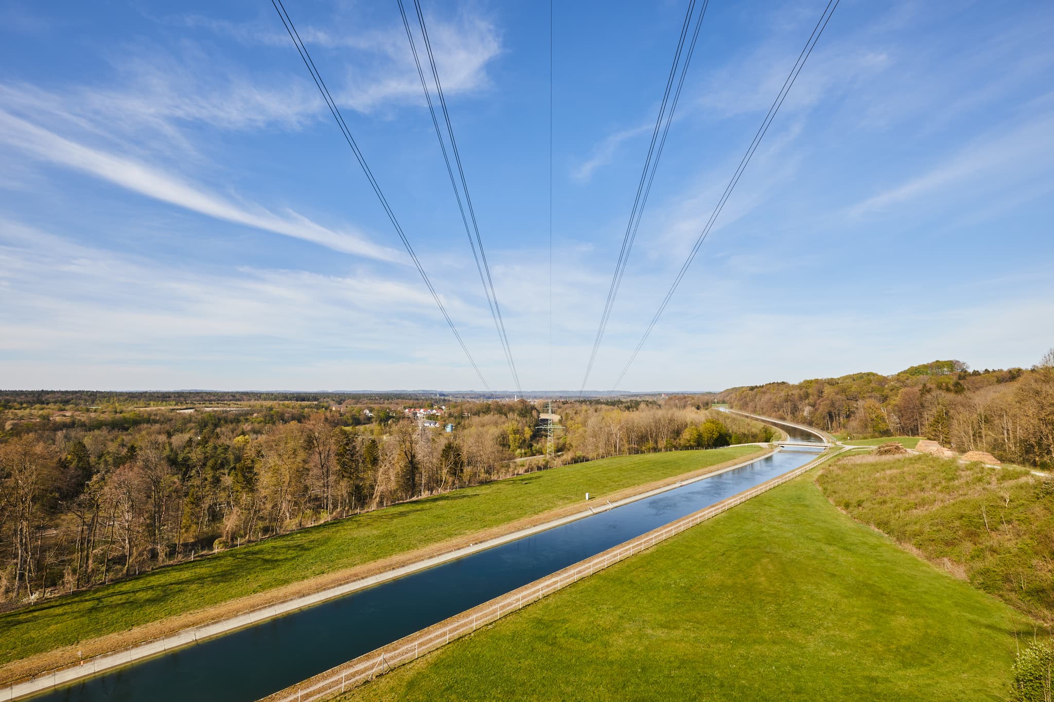 Der Alzkanal in Burgkirchen, Altötting, Oberbayern, prägt die Landschaft der Region Inn-Salzach. Blick auf den Kanal und Stromleitungen.