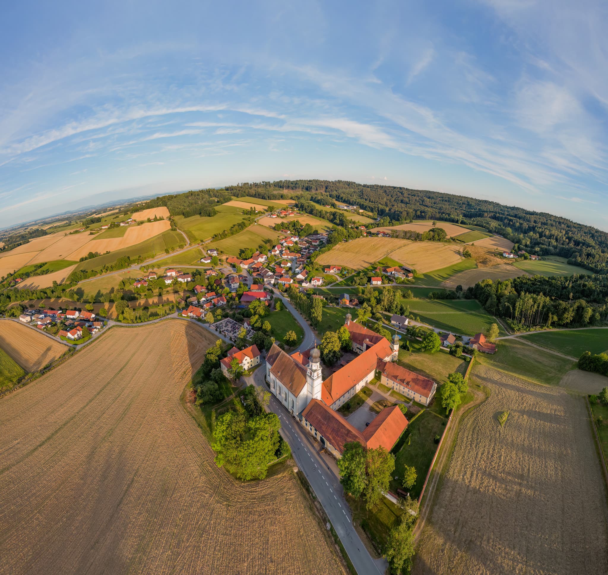 Luftbild der St. Salvator Klosterkirche in Bad Griesbach, Landkreis Passau, Niederbayern. Die Kirche steht inmitten einer hügeligen Landschaft mit Feldfluren.