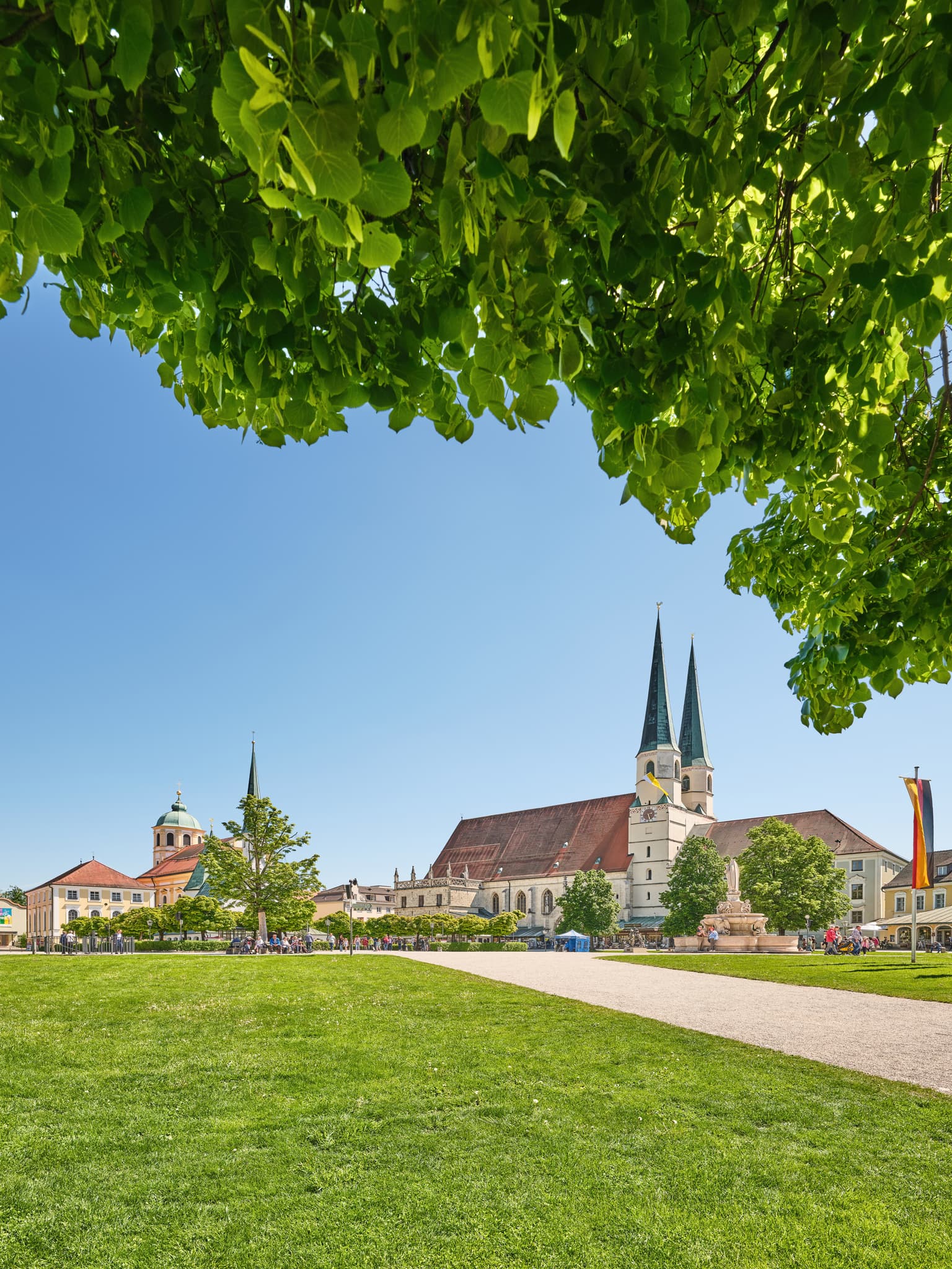 Kapellplatz Altötting, Oberbayern, Inn-Salzach, Deutschland. Blick auf die Stiftskirche und weitläufige Grünflächen.