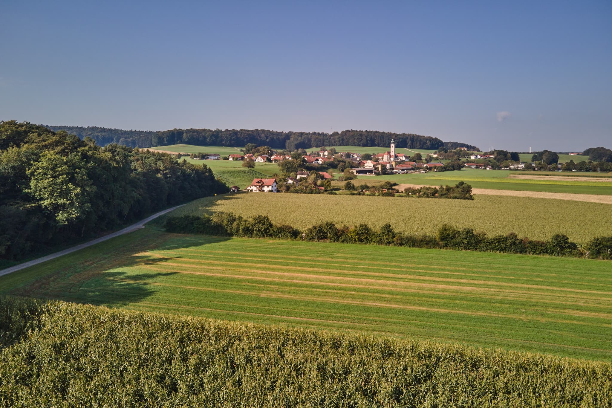 Dorf Badhöring bei Mehring im Landkreis Altötting, Oberbayern. Landschaft der Region Inn-Salzach, Deutschland, zeigt Felder und Wälder entlang eines Pilgerwegs.