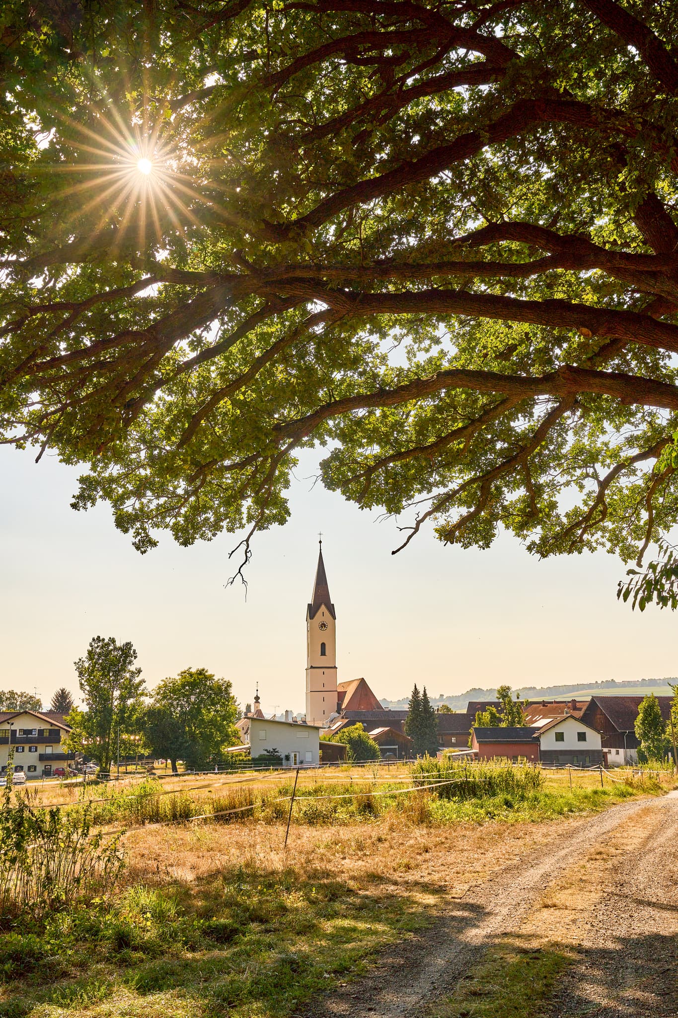 Idyllische Landschaft mit Kirche und Baum in Karpfham, Bad Griesbach, Landkreis Passau, Niederbayern, Deutschland. Eine Ansicht des Bäderdreiecks.