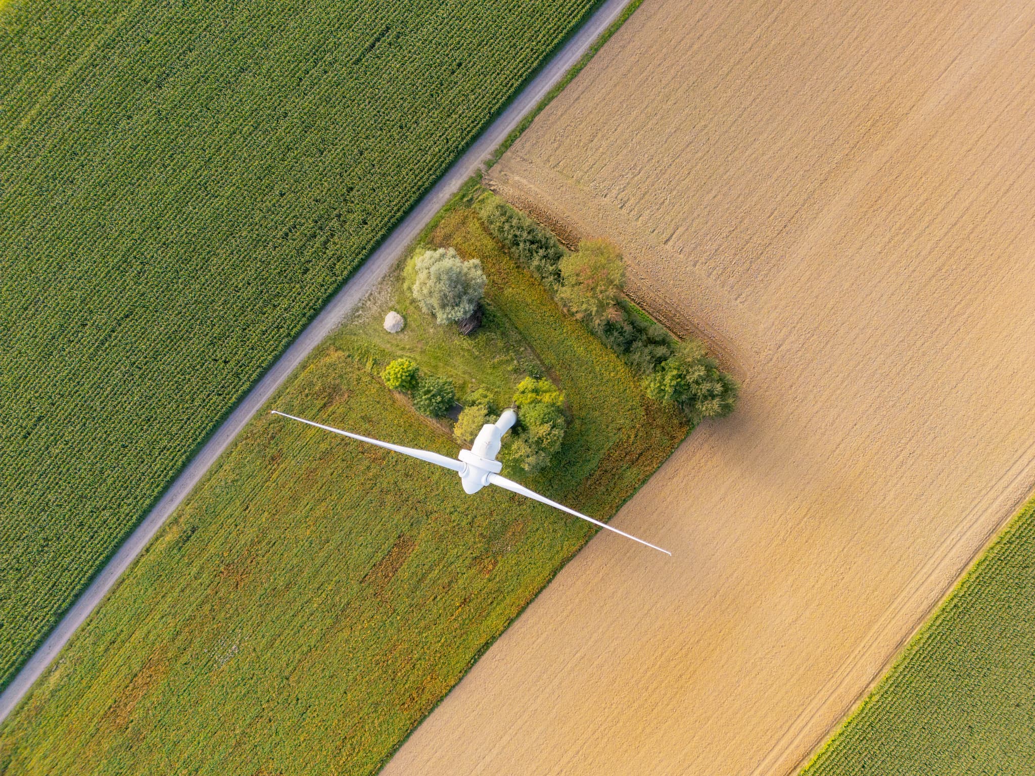 Zwei Windkraftanlagen inmitten weitläufiger Felder und grüner Landschaft bei Dirnaich, Gangkofen, im Landkreis Rottal-Inn, Niederbayern, Holzland.