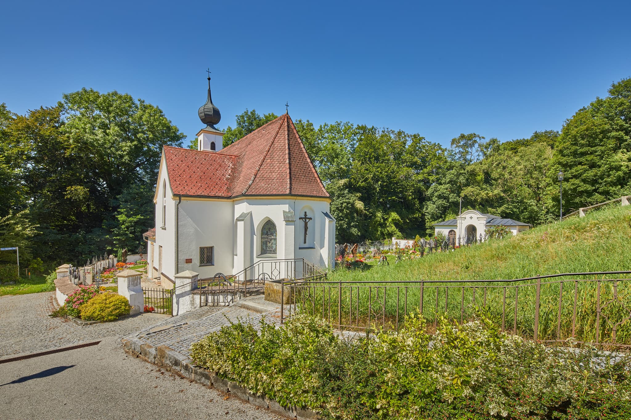 Pfarrkirche Radegundis in Hadermarkt, St. Radegund, Braunau am Inn, Oberösterreich, Innviertel, Österreich. Kirchengebäude in grüner Landschaft.