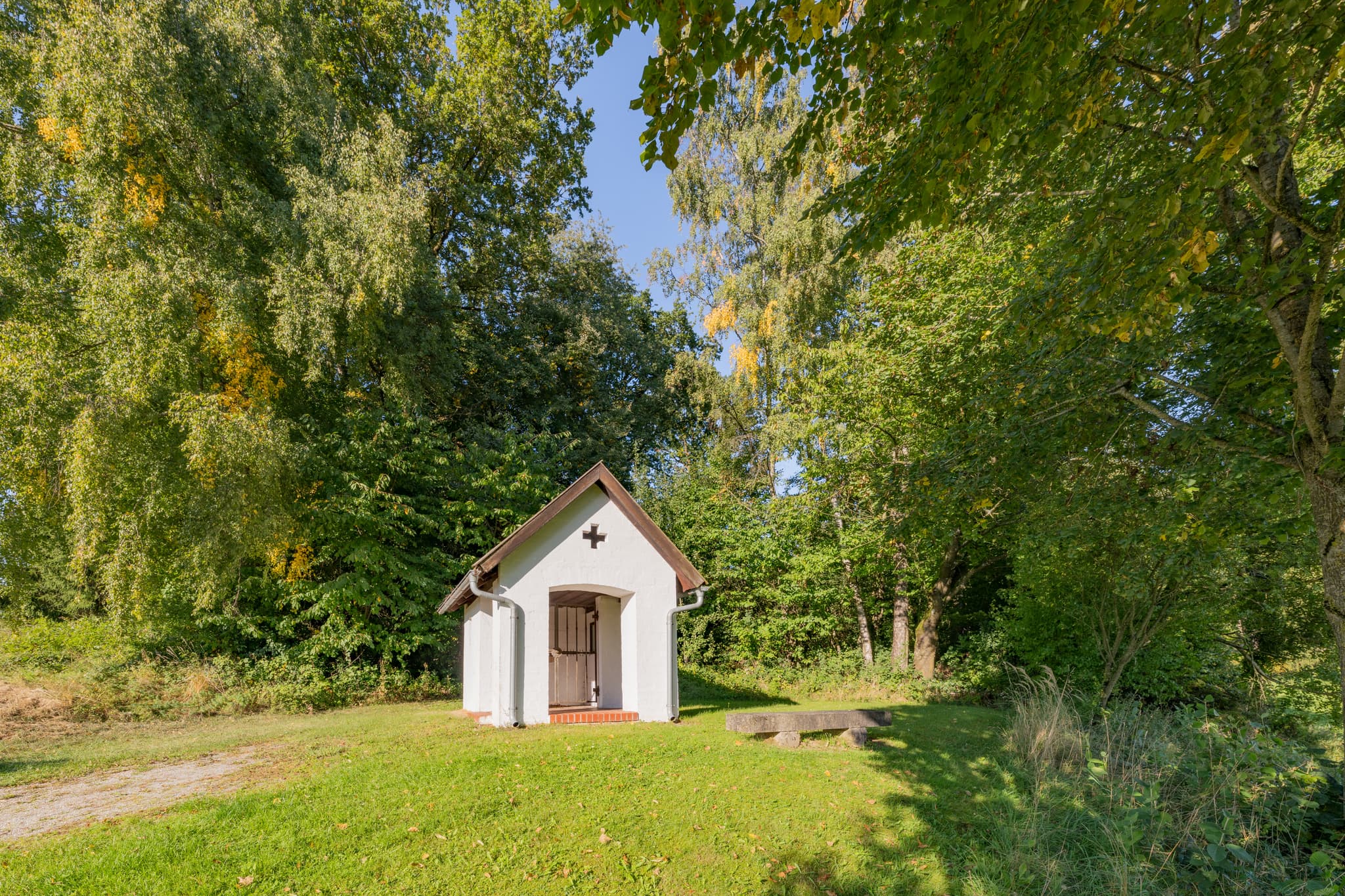 Bruder Konrad Kapelle in Hirschbach, Bad Birnbach, Rottal-Inn, Niederbayern, Deutschland. Kleine Kapelle, umgeben von grünen Bäumen und Wiesen im Bäderdrieck.