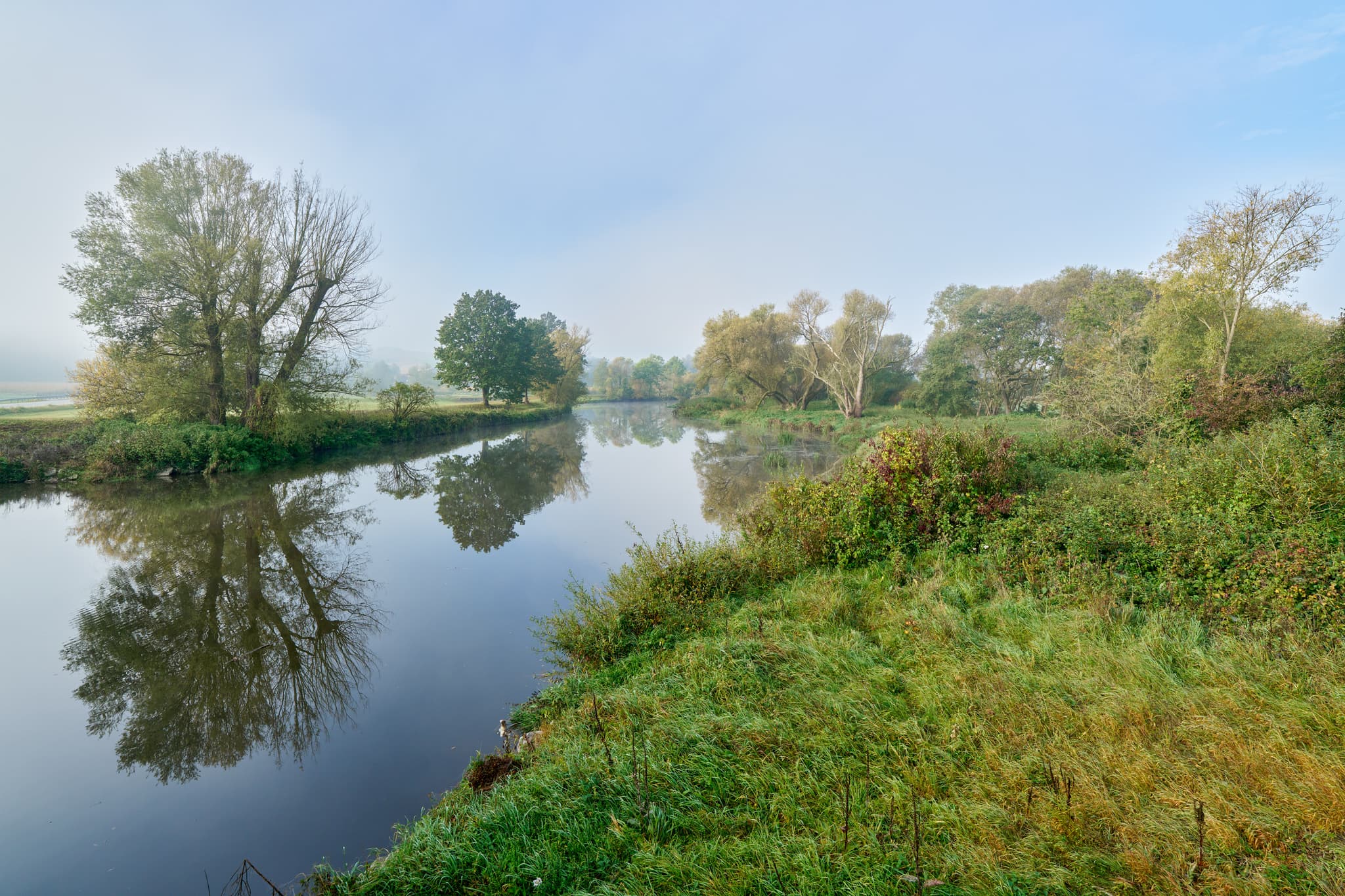 Der Fluss Rott bei Bad Birnbach, Rottal-Inn, Niederbayern. Ruhiges Wasser und grüne Ufer mit Bäumen spiegeln sich wider. Eine herbstliche Szene im Bäderdrieck.