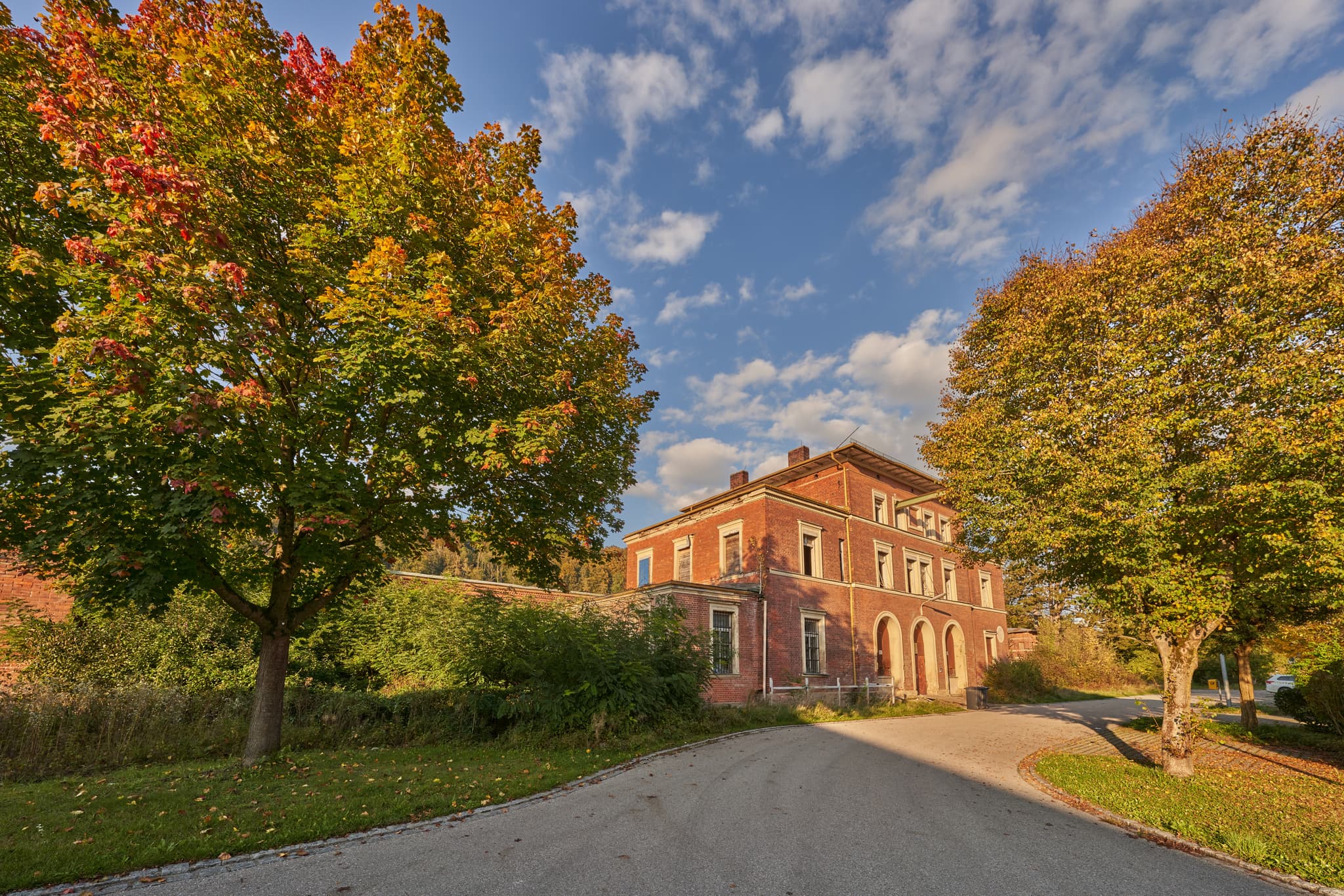 Historischer Bahnhof Eisenfelden in Winhöring, Altötting, Oberbayern. Gebäude im Inn-Salzach-Gebiet in Deutschland ist umgeben von herbstlichen Bäumen