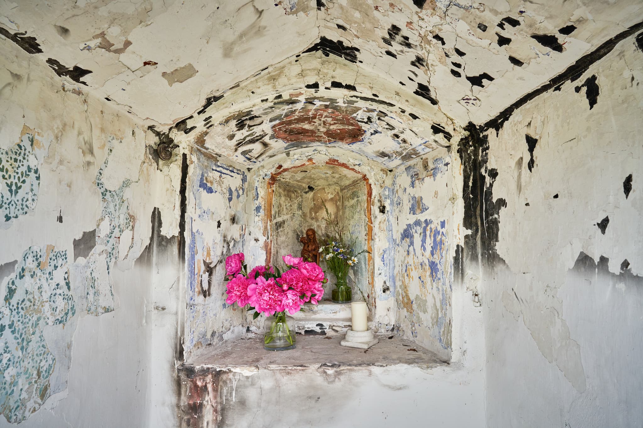 Historischer Bildstock am Höresham Weg, Burgkirchen, Altötting, Oberbayern. Verwitterte Nische mit Figur und Blumen. Kulturelles Zeugnis der Inn-Salzach-Region.