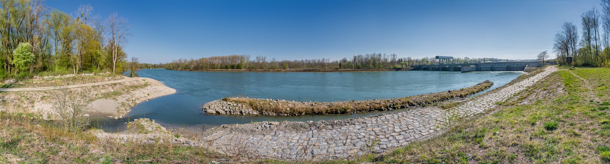 Panoramablick auf den Inn mit Fischtreppe und Kraftwerk bei Stammham in Altötting, Oberbayern. Die Landschaft zeigt den Flusslauf und grüne Uferbereiche.