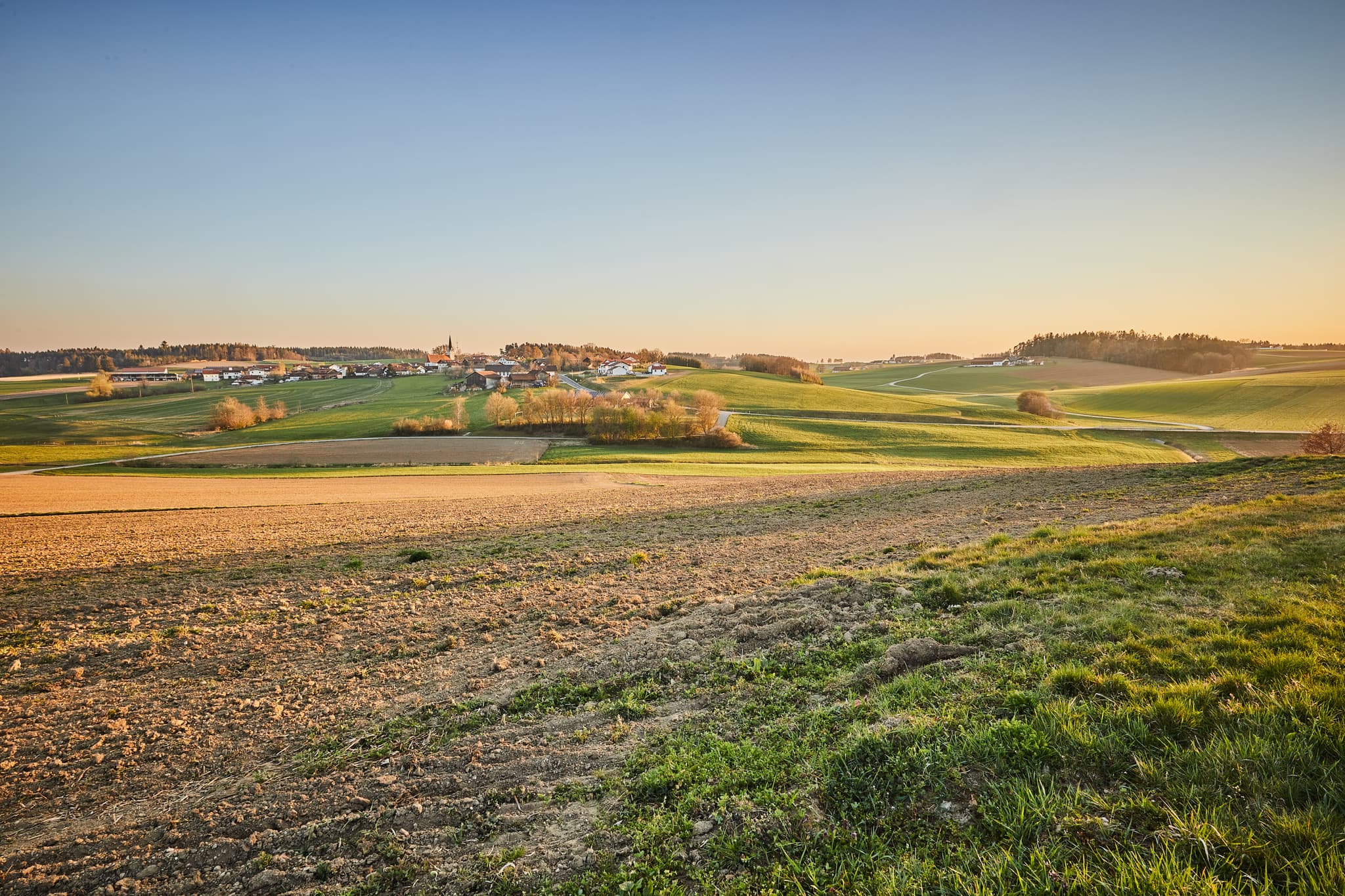 Landschaftsbild Arbing und Ecking, Reischach, Landkreis Altötting, Oberbayern. Sanfte Hügel und Felder der Region Inn-Salzach, Deutschland, im Abendlicht.
