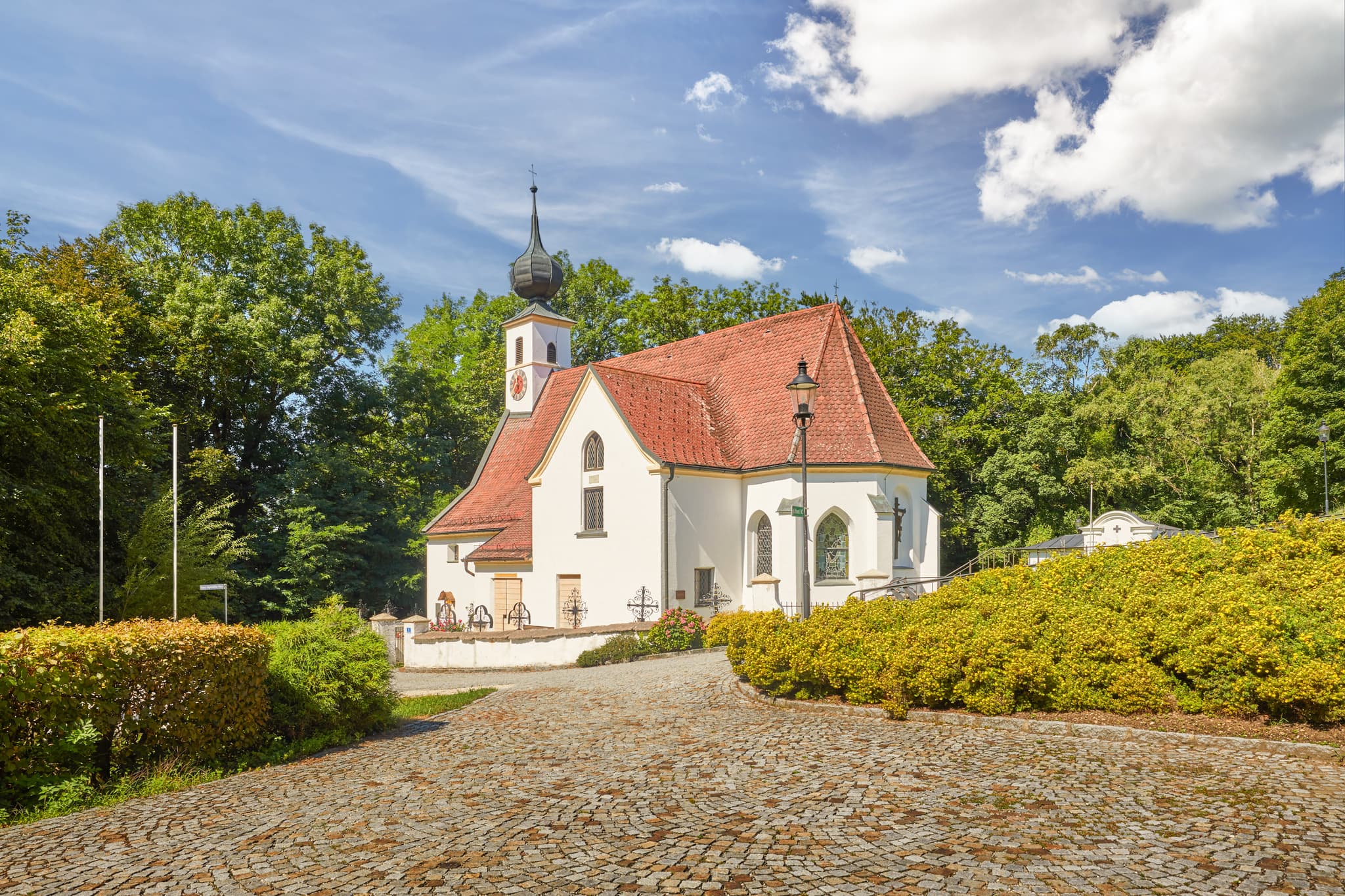 Pfarrkirche Radegundis in Hadermarkt, St. Radegund, Braunau am Inn, Oberösterreich, Innviertel, Österreich. Kirchengebäude in grüner Landschaft.