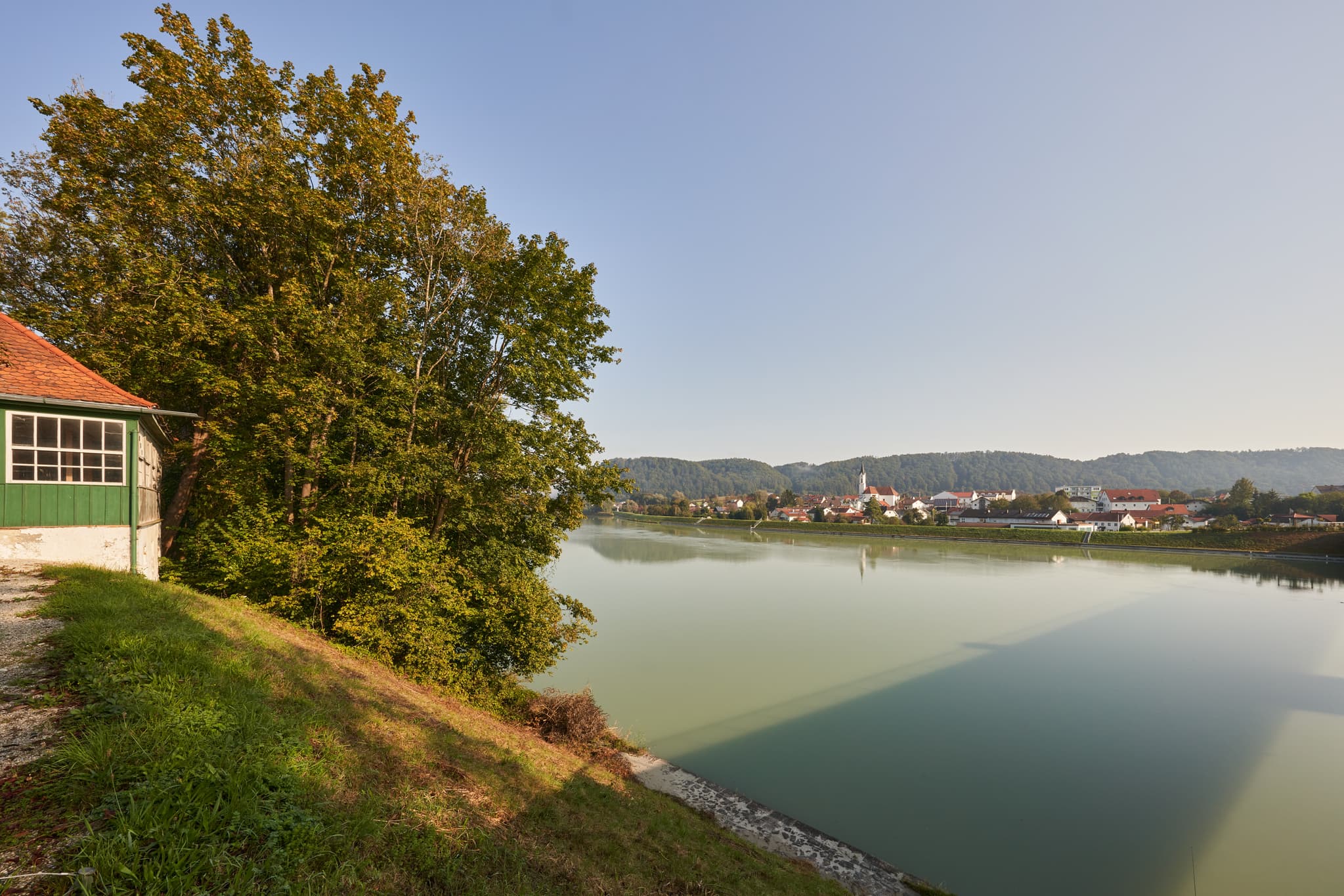 Herrliche Aussicht auf die Innbrücke und Marktl am Inn in Oberbayern, Region Inn-Salzach, Deutschland. Ein idyllisches Bild mit Fluss und Häusern.