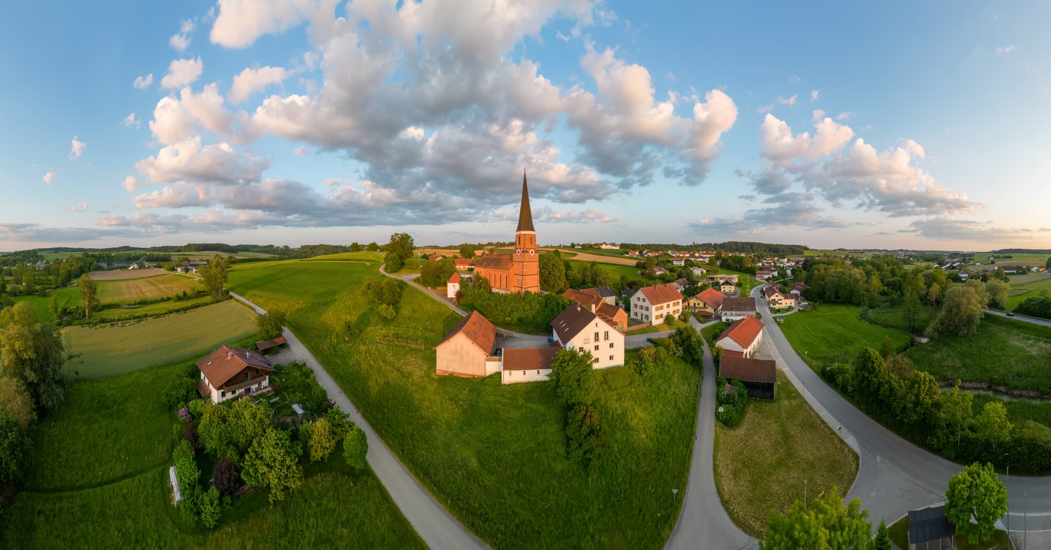 Pfarrkirche St. Rupert in Hirschhorn, Wurmannsquick, Rottal-Inn, Niederbayern. Ländliche Szenerie im Holzland, Deutschland, mit Feldern und Häusern.