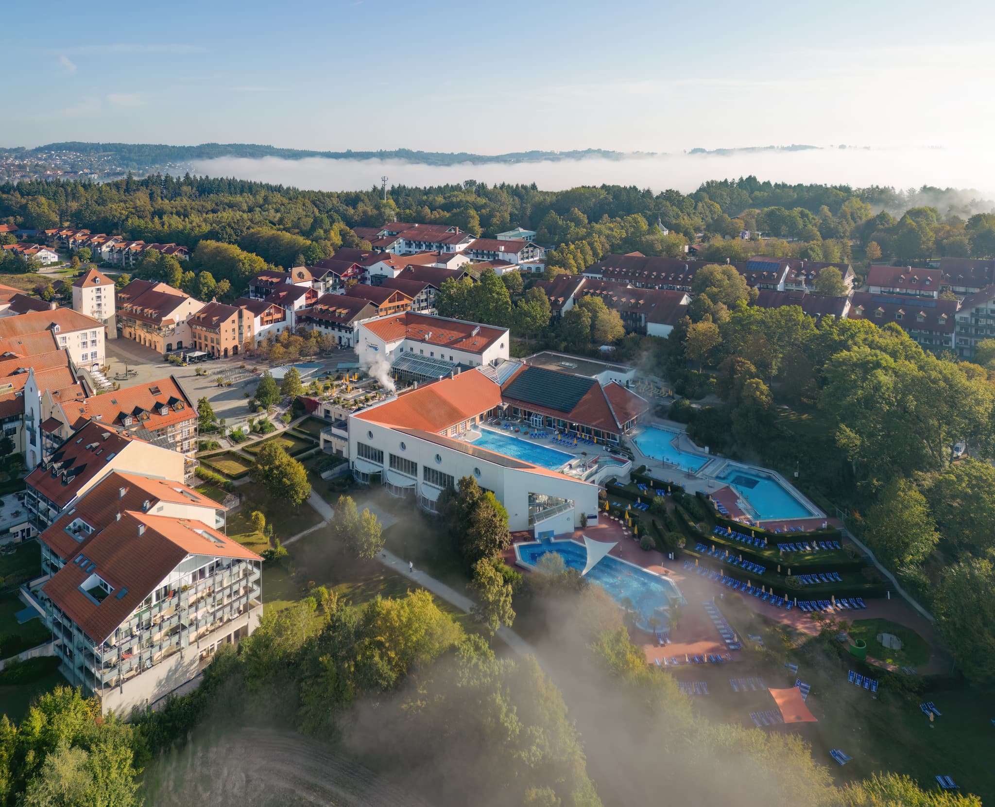Luftbildaufnahme der Therme Bad Griesbach im Herbst. Das Bild zeigt die Außenanlagen mit Pools und die umliegende Landschaft. Landkreis Passau, Niederbayern.