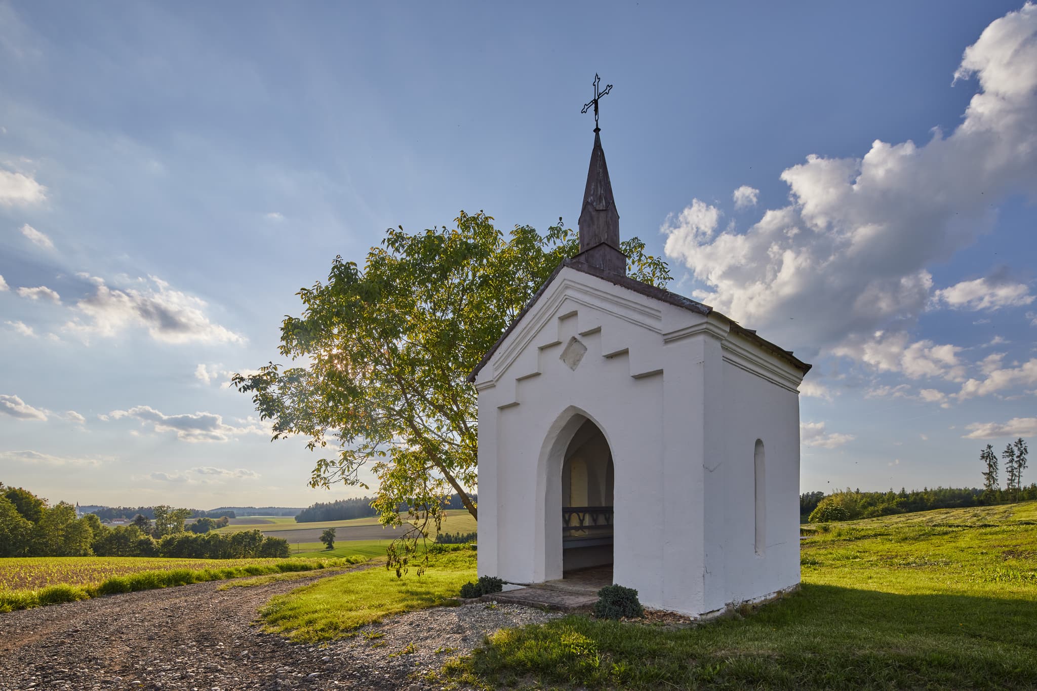 Bild einer kleinen Kapelle in Albersberg, Gemeinde Pleiskirchen, Altötting, Oberbayern, Holzland, Bayern, Deutschland. Kapelle ländlicher Umgebung mit Feldern.