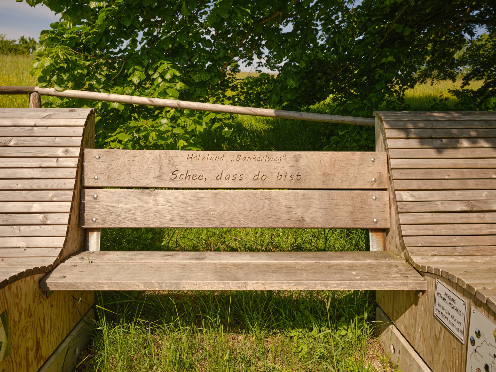 Hölzerne Sitzbank am Waldrand in Steinhausen, Ortsteil Erlbach, Landkreis Altötting, Oberbayern. Region Inn-Salzach, Deutschland. Eine ideale Rastmöglichkeit.