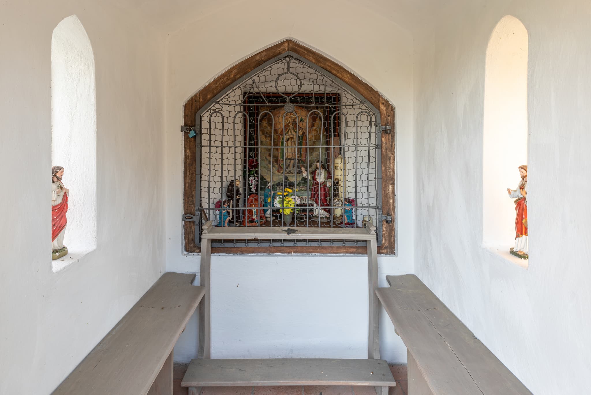 Blick in eine Kapelle in Rockersbach, Ortsteil Reischach, Landkreis Altötting, Oberbayern. Sie beherbergt Altar, Figuren, Bänke und Statuen.