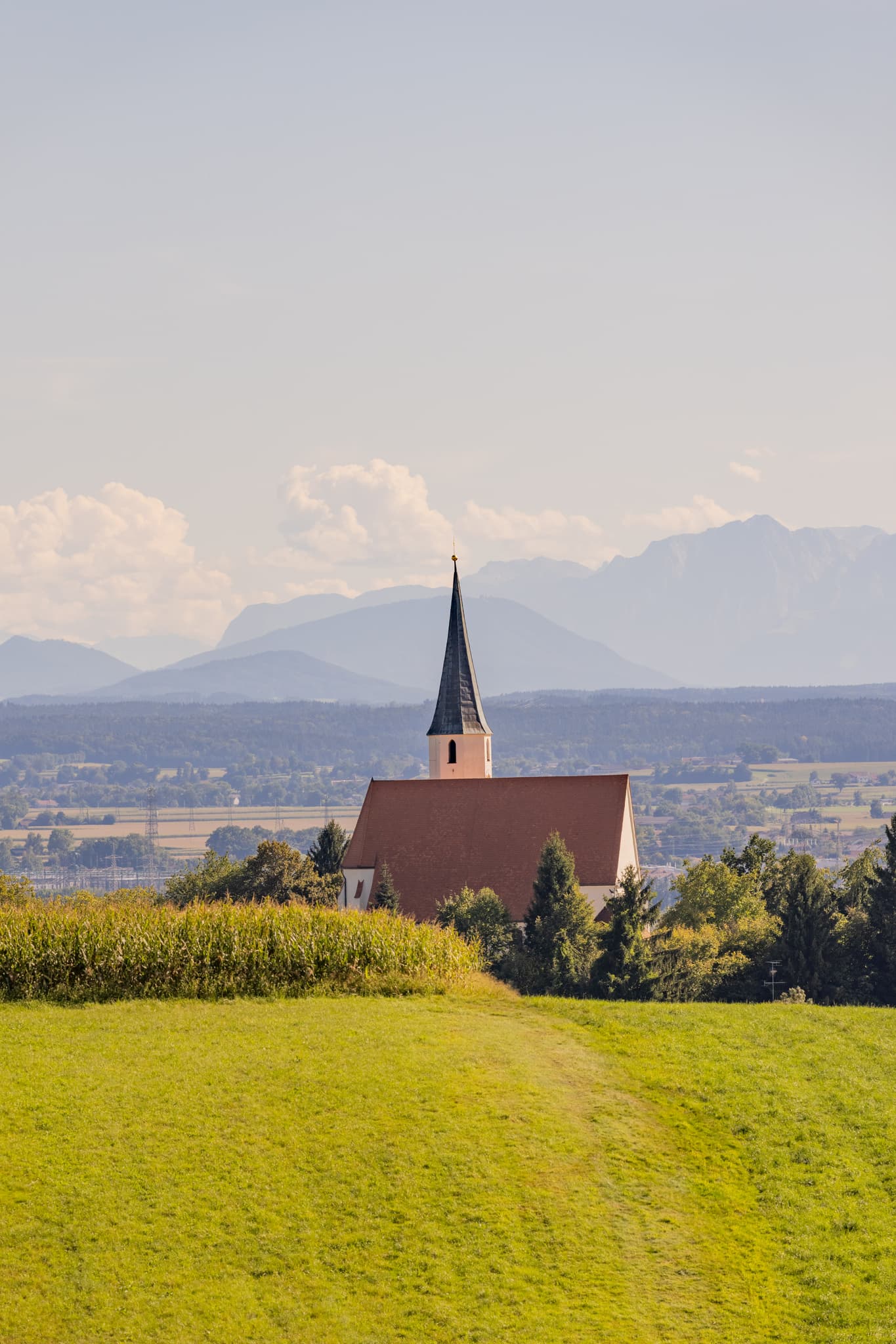 Pfarrkirche St. Georg und Urban in Stubenberg, Rottal-Inn, Niederbayern. Kirche mit weitem Alpenblick und Bergpanorama, Holzland, Deutschland.