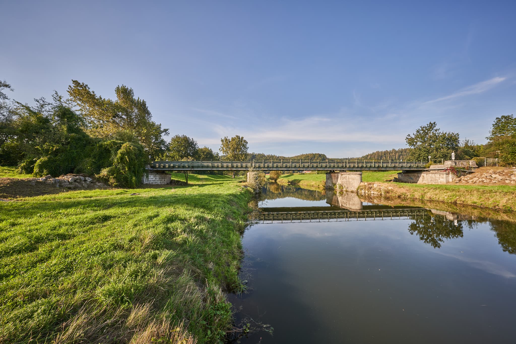Landschaftsbild mit Brücke über die Isen mit grünen Ufern und Bäumen in Kronberg Isen, Winhöring, Landkreis Altötting, Oberbayern, Inn-Salzach, Deutschland.