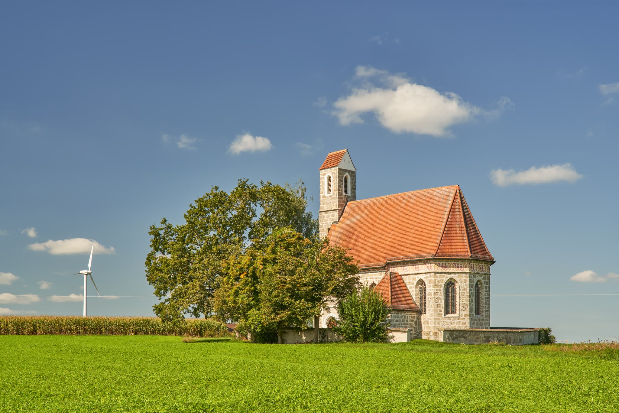 Kirche St. Alban, Peterskirchen, Tacherting, Landkreis Traunstein, Oberbayern. Motiv der Kirche umgeben von Feldern im Chiemgau, Deutschland.