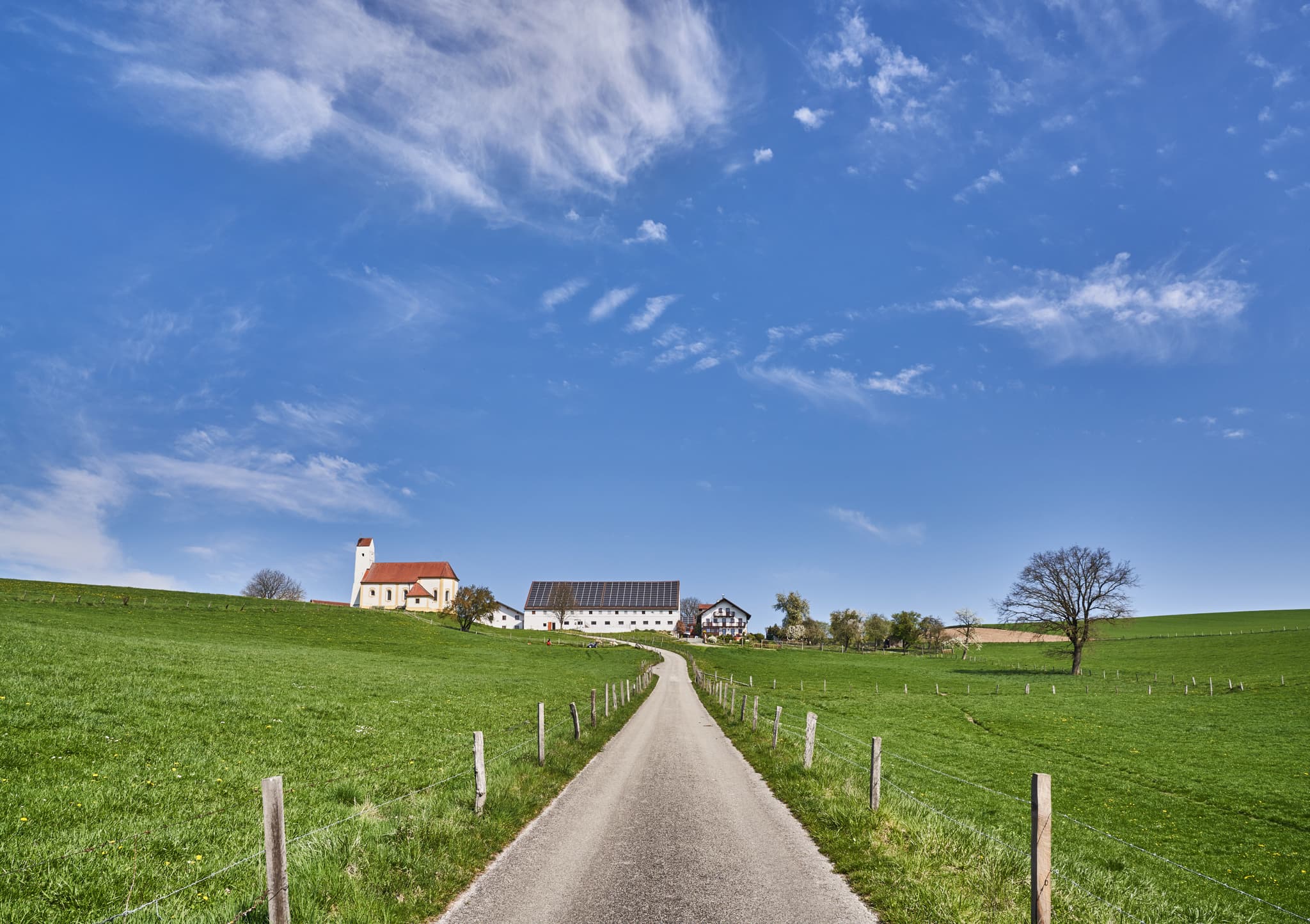 Idyllische Kirche Sankt Pankratius in Mettenheim, Mühldorf am Inn, Oberbayern, Region Inn-Salzach, Deutschland. Landschaftsbild mit Feldweg und Weitblick.