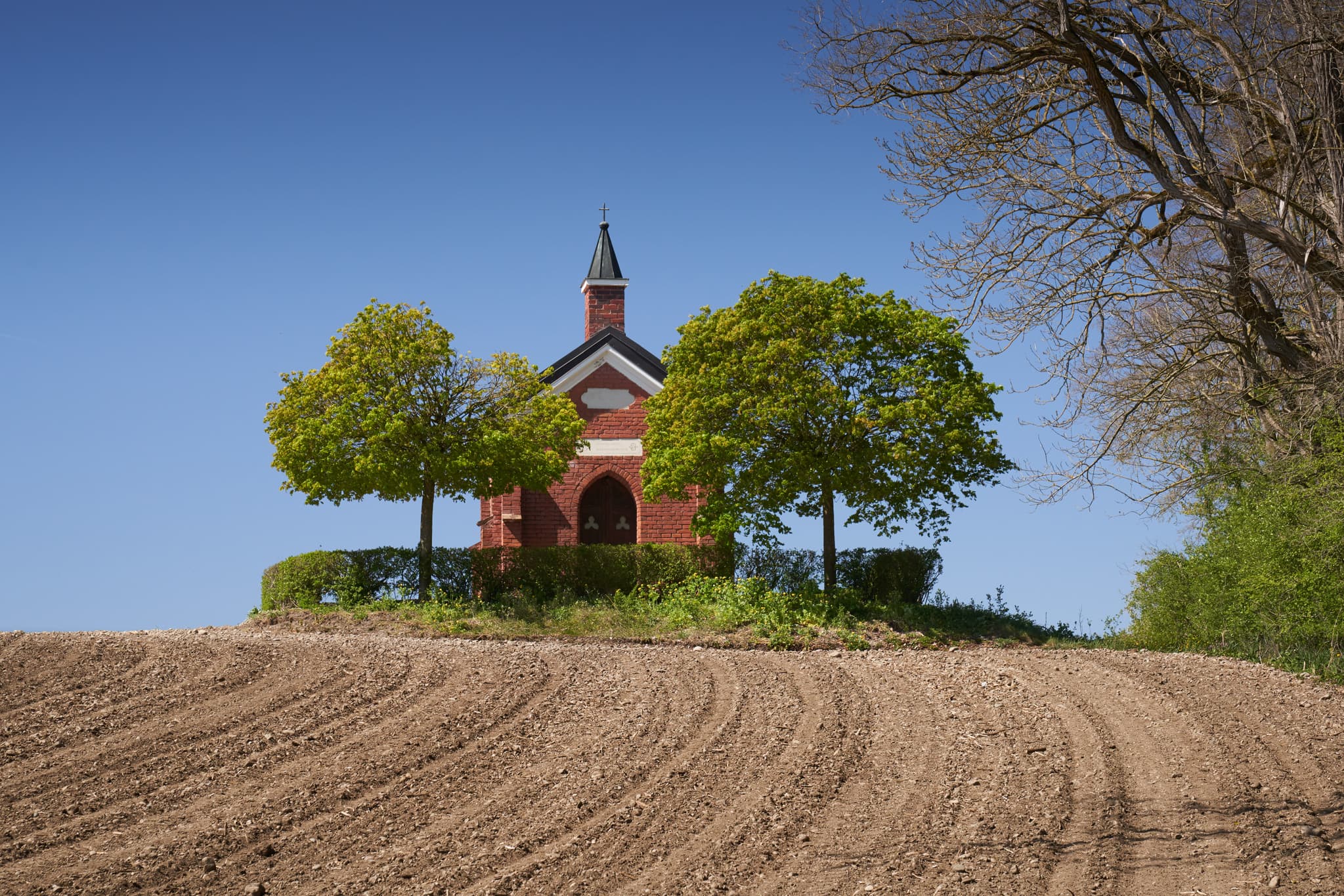 Die Isen Kapelle in Winhöring, Landkreis Altötting, Oberbayern, Deutschland. Das Bild zeigt das ländliche Bauwerk umgeben von Natur in der Region Inn-Salzach.