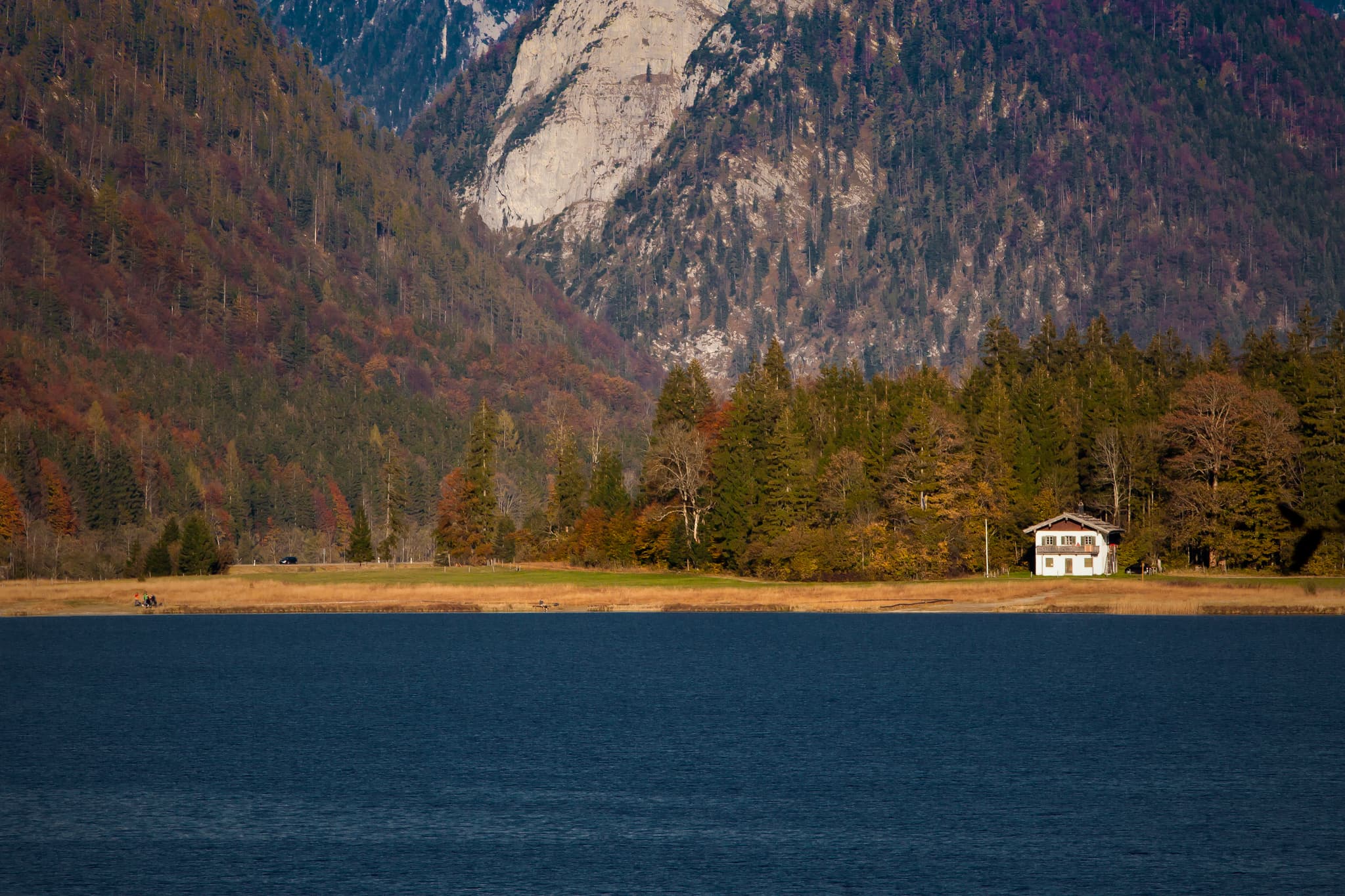 Blick über den Weitsee mit Herbstwäldern, Bergen und einem Haus am Ufer. Aufnahme bei Reit im Winkl, Landkreis Traunstein, Oberbayern, Chiemgau, Deutschland.