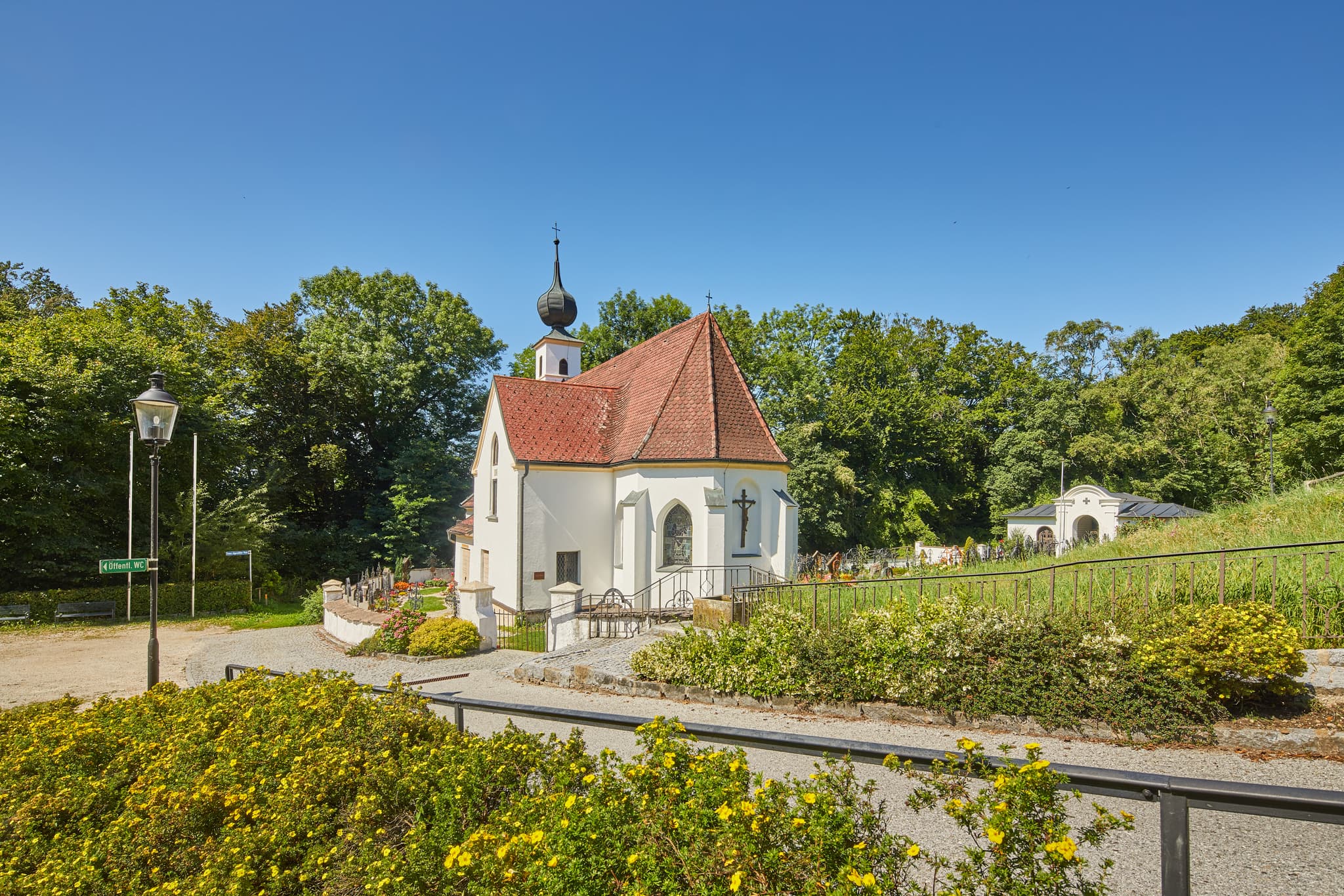 Pfarrkirche Radegundis in Hadermarkt, St. Radegund, Braunau am Inn, Oberösterreich, Innviertel, Österreich. Kirchengebäude in grüner Landschaft.