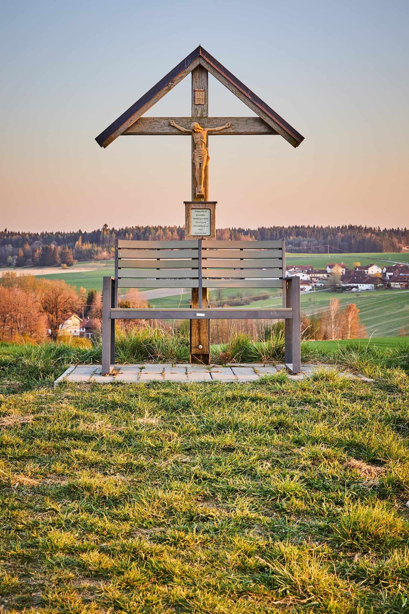 Feldkreuz mit Sitzbank bietet eine weite Aussicht über die Landschaft bei Arbing, Reischach, im Landkreis Altötting, Oberbayern, Holzland, Deutschland.