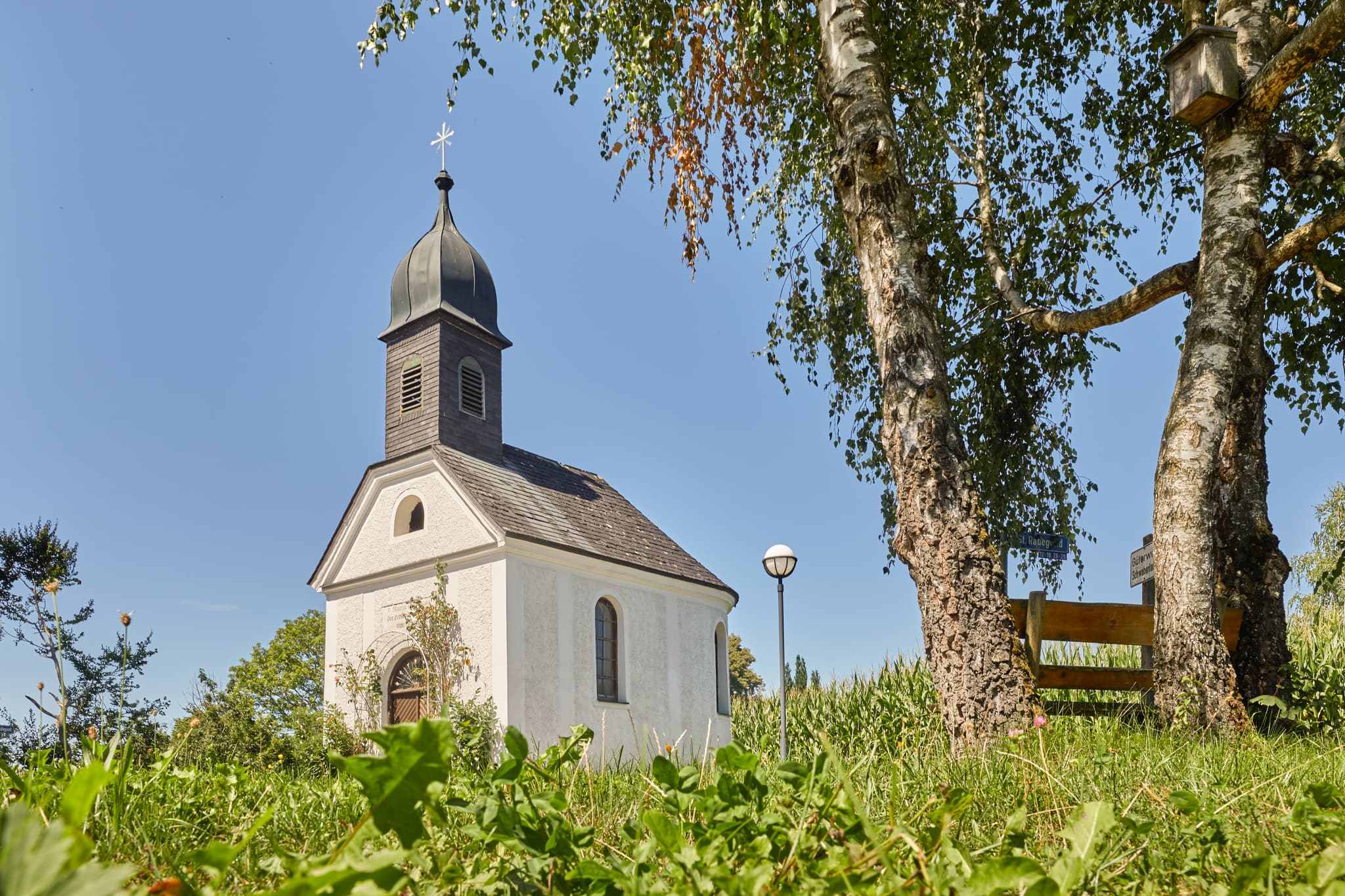 Kapelle in St. Radegund, Oberösterreich, im ländlichen Innviertel. Das Gotteshaus steht umgeben von Bäumen und Maisfeldern im Bezirk Braunau am Inn, Österreich.