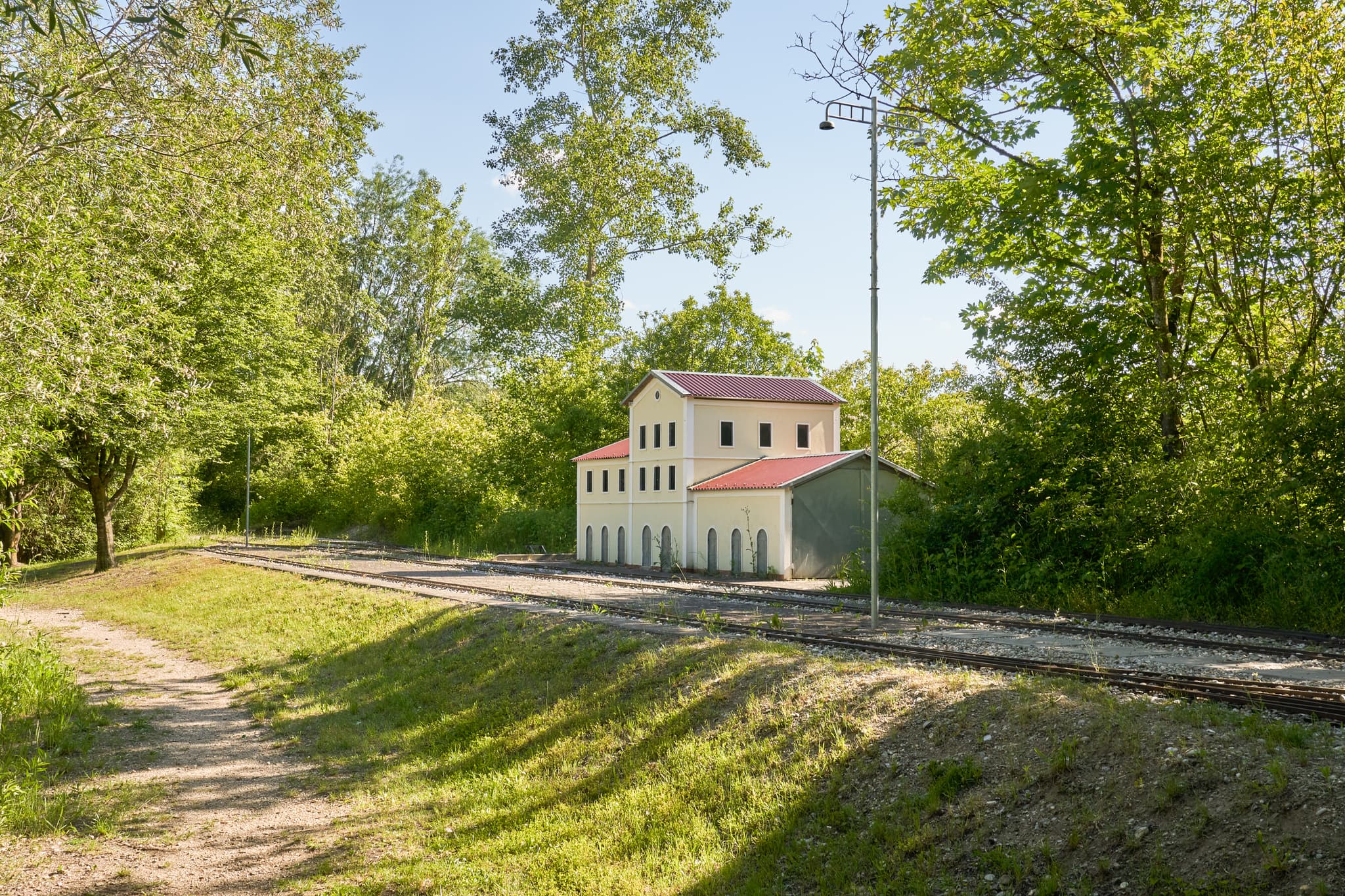 Miniatur-Parkbahnanlage in Neuötting, Altötting, Oberbayern. Szene zeigt Modellgleise, Gebäude und grünen Baumbestand. Region Inn-Salzach, Deutschland.