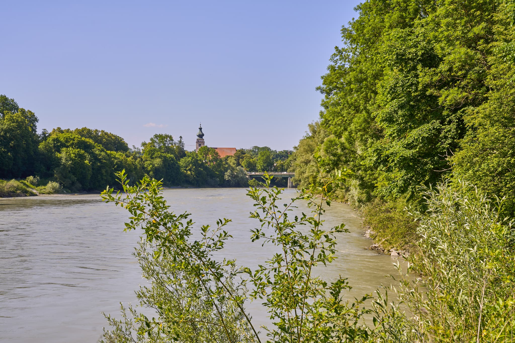 Fluss Inn, Naturerlebnisweg Innaue in Mühldorf. Grüne Ufer, Bäume. Kirchturm, Brücke. Landkreis Mühldorf am Inn, Inn-Salzach, Oberbayern, Naturlandschaft.