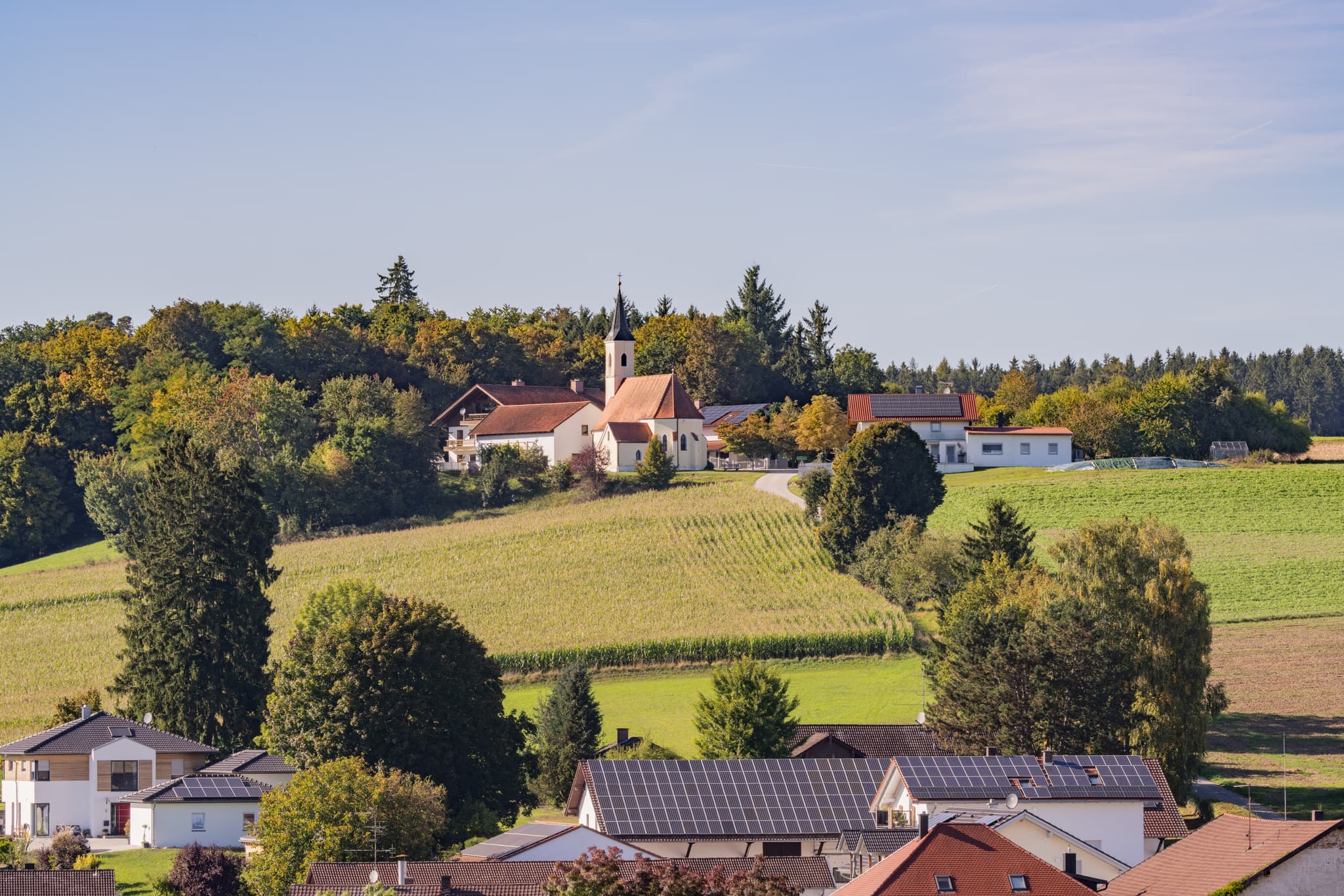 Blick von Schwaigeröd auf Guteneck,  Johanniskirchen, Rottal-Inn, Niederbayern, Deutschland. Kirche und Häuser sind von Feldern umgeben, Holzland.