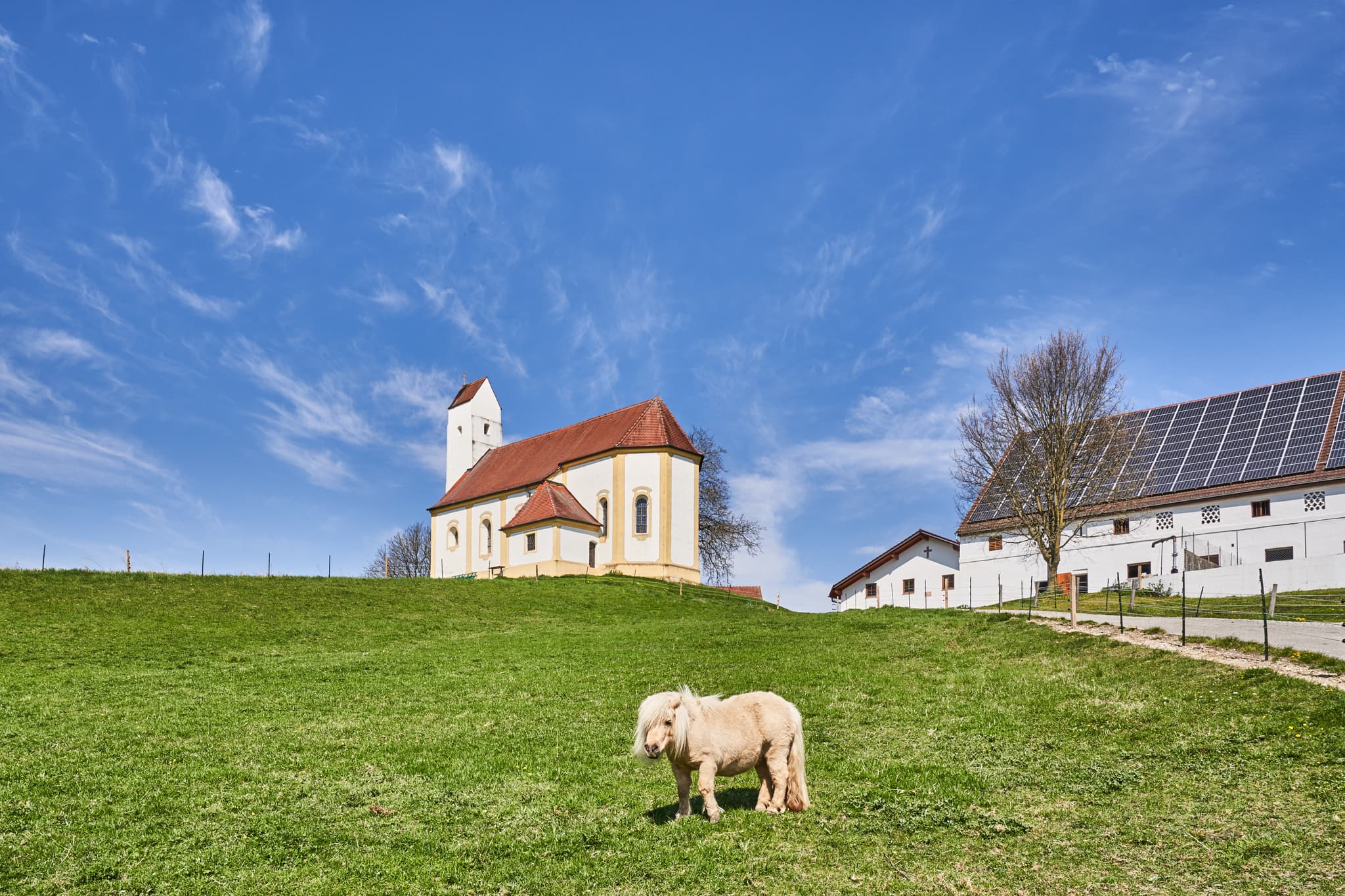 Idyllische Landschaftsaufnahme zwischen Kirchisen und Kainrading mit Feldern und Wald bei Mettenheim im Landkreis Mühldorf am Inn, Oberbayern.