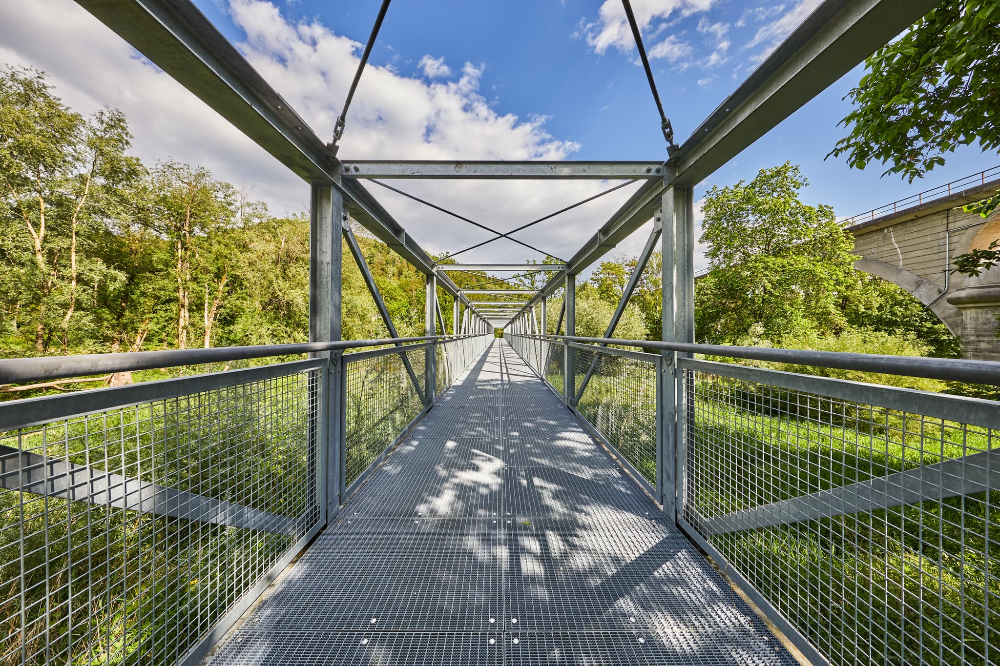 Neue Fahrrad- und Fußgängerbrücke in Garching, Landkreis Altötting. Die moderne Brücke über grüner Landschaft, Oberbayern, Region Inn-Salzach, Deutschland.