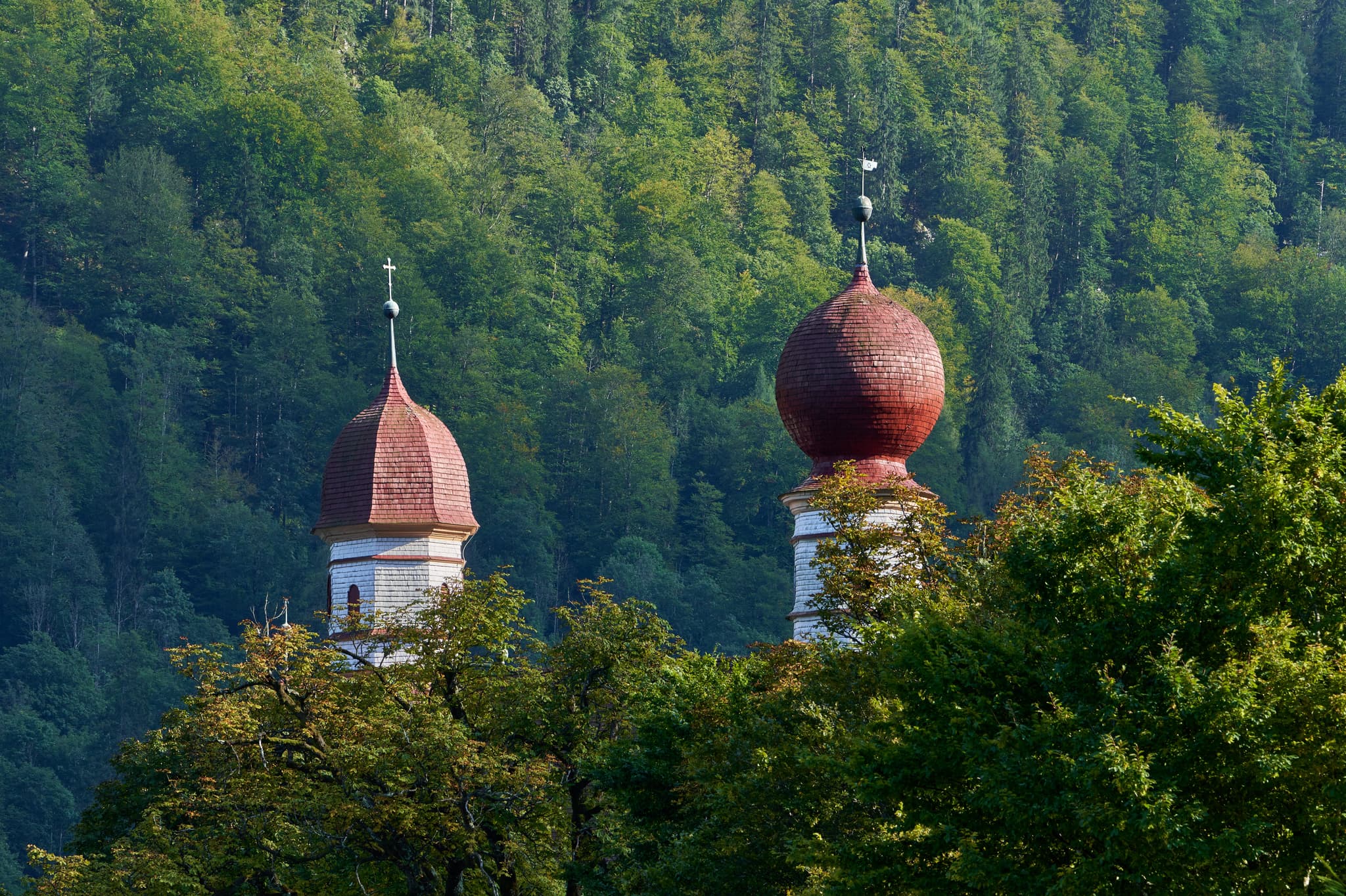 Kirchtürme St. Bartholomä am Königssee in Schönau, Berchtesgadener Land, Oberbayern, Deutschland. Die Berchtesgadener Alpen bilden eine malerische Bergkulisse.