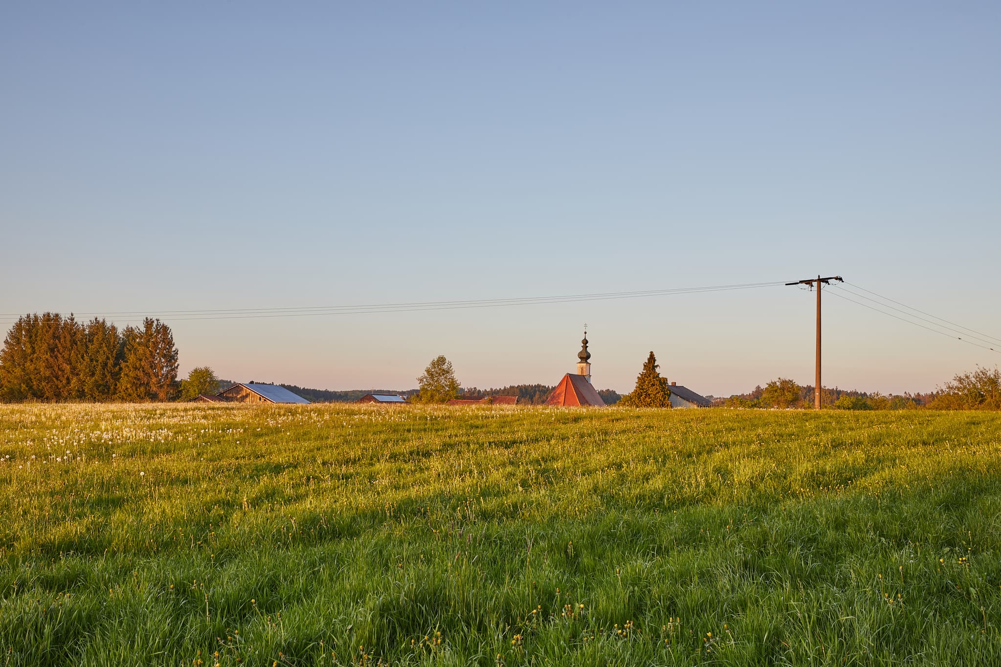 Entdecken Sie die Schönheit von Atzberg in Mitterskirchen, Landkreis Rottal-Inn, Bayern. Ein bezauberndes Foto zeigt die malerische Landschaft und die Kirche.
