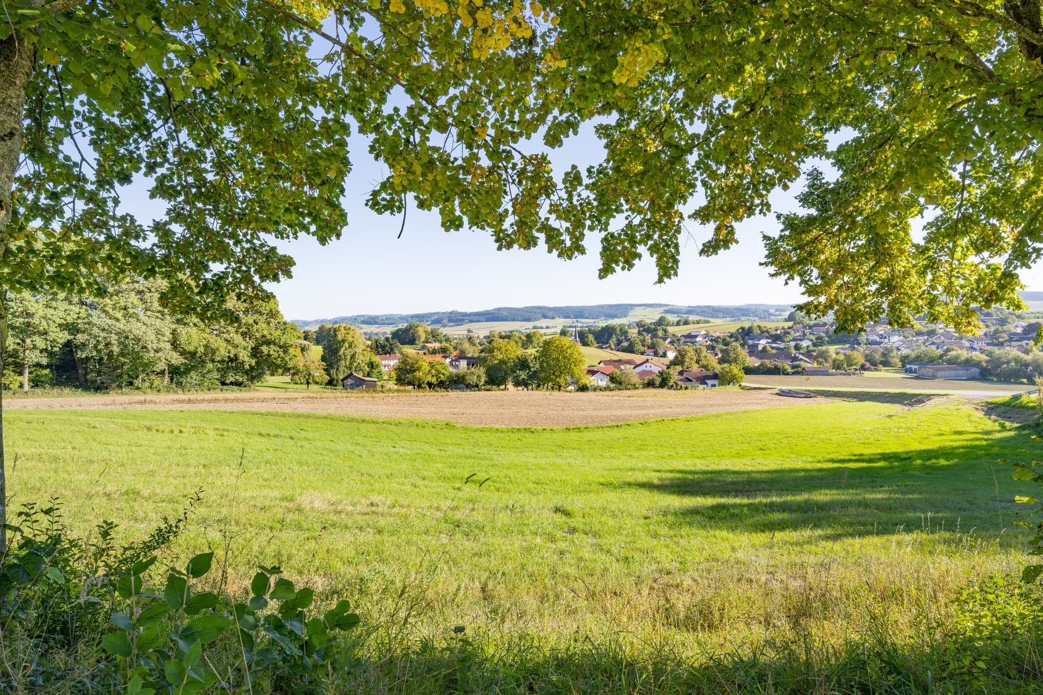 Blick auf Hirschbach von Bruder Konrad Kapelle, Bad Birnbach. Grüne Wiesen, Siedlung Rottal-Inn, Niederbayern, Deutschland. Landschaft des Bäderdriecks.