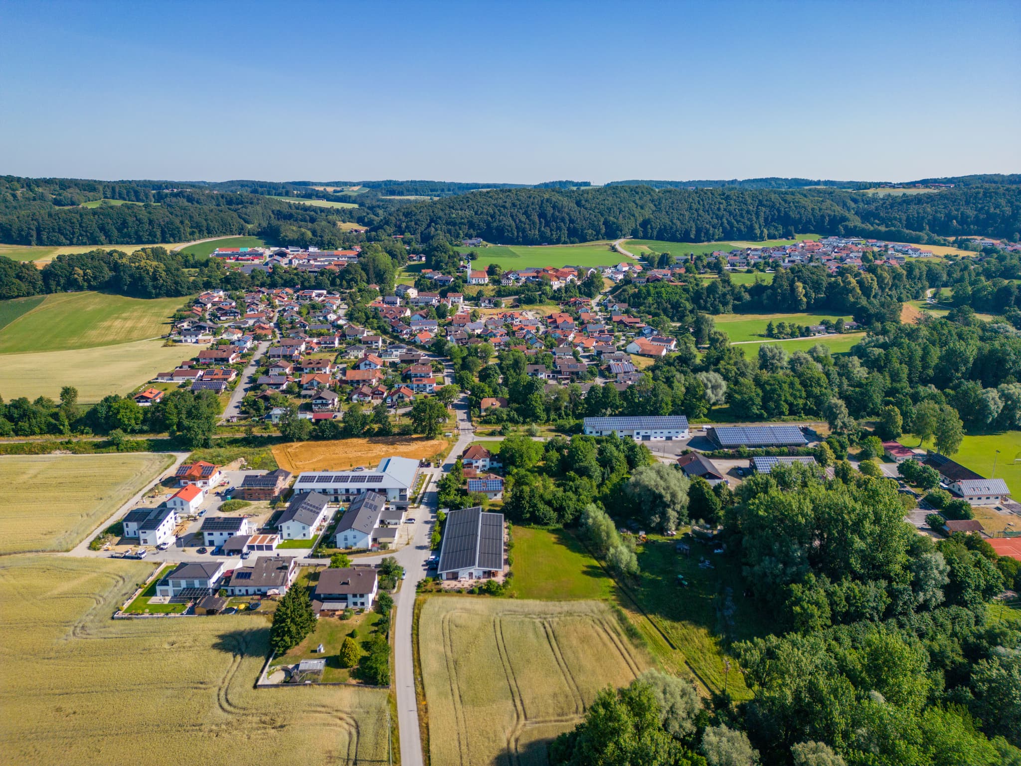 Luftaufnahme von Perach im Landkreis Altötting, Oberbayern. Zeigt eine Ortsansicht mit Wohngebäuden, Feldern und Wäldern in der Region Inn-Salzach, Deutschland.