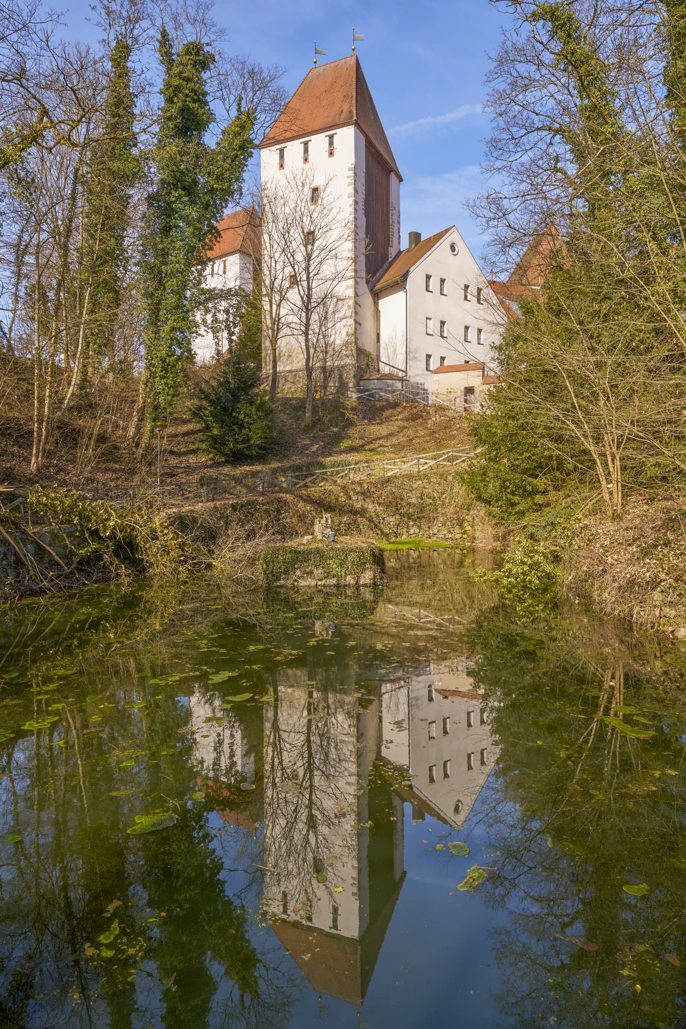 Historisches Schloss Neuburg am Inn in Niederbayern, Deutschland. Die Anlage im Landkreis Passau spiegelt sich im Wasser, umgeben von Bäumen, Donau-Wald Region.