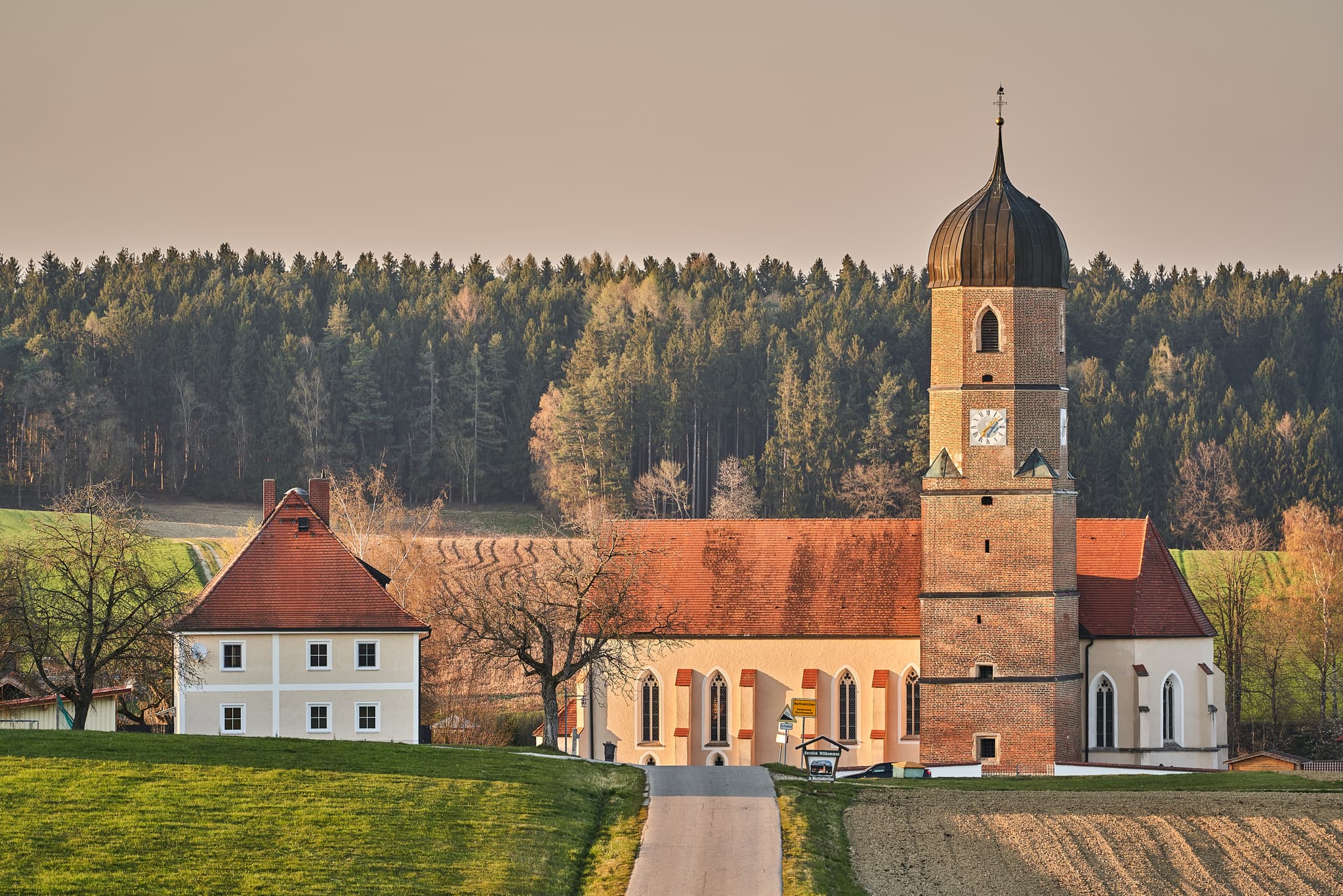 Kirche in Martinskirchen, Ortsteil Wurmannsquick, Landkreis Rottal-Inn, Niederbayern, Holzland, Deutschland. Die ländliche Umgebung prägt das Bild.