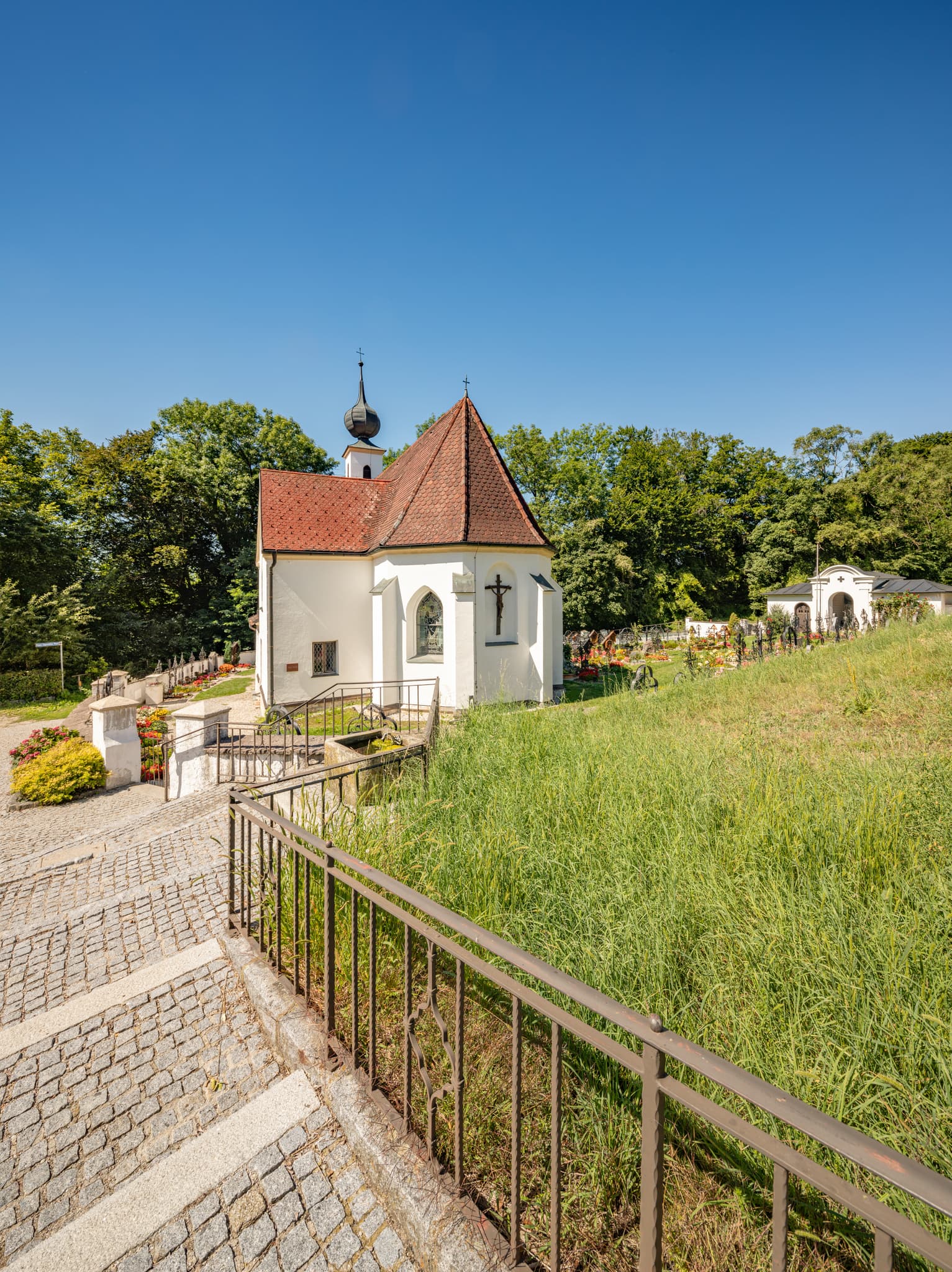 Pfarrkirche Radegundis in Hadermarkt, St. Radegund, Braunau am Inn, Oberösterreich, Innviertel, Österreich. Kirchengebäude in grüner Landschaft.