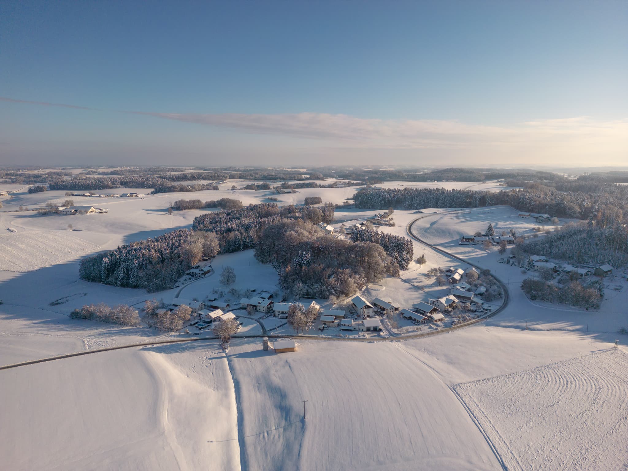 Luftbild von Waldberg, Reischach, Landkreis Altötting, Oberbayern. Verschneite Landschaft der Inn-Salzach-Region in Deutschland mit Häusern und Wäldern.