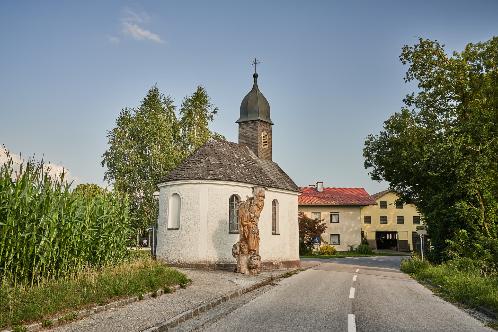 Kapelle in St. Radegund, Oberösterreich, im ländlichen Innviertel. Das Gotteshaus steht umgeben von Bäumen und Maisfeldern im Bezirk Braunau am Inn, Österreich.