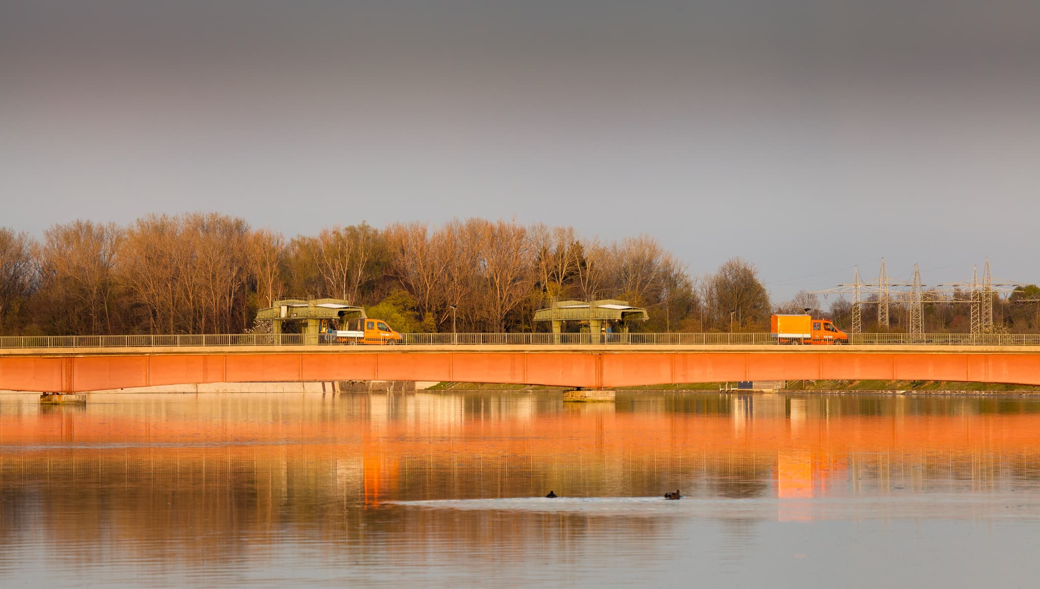 Die Innbrücke mit Kraftwerk in Neuötting, Altötting, Oberbayern, Deutschland. Brücke mit Fahrzeugen über den Inn. Typische Landschaft der Inn-Salzach Region.