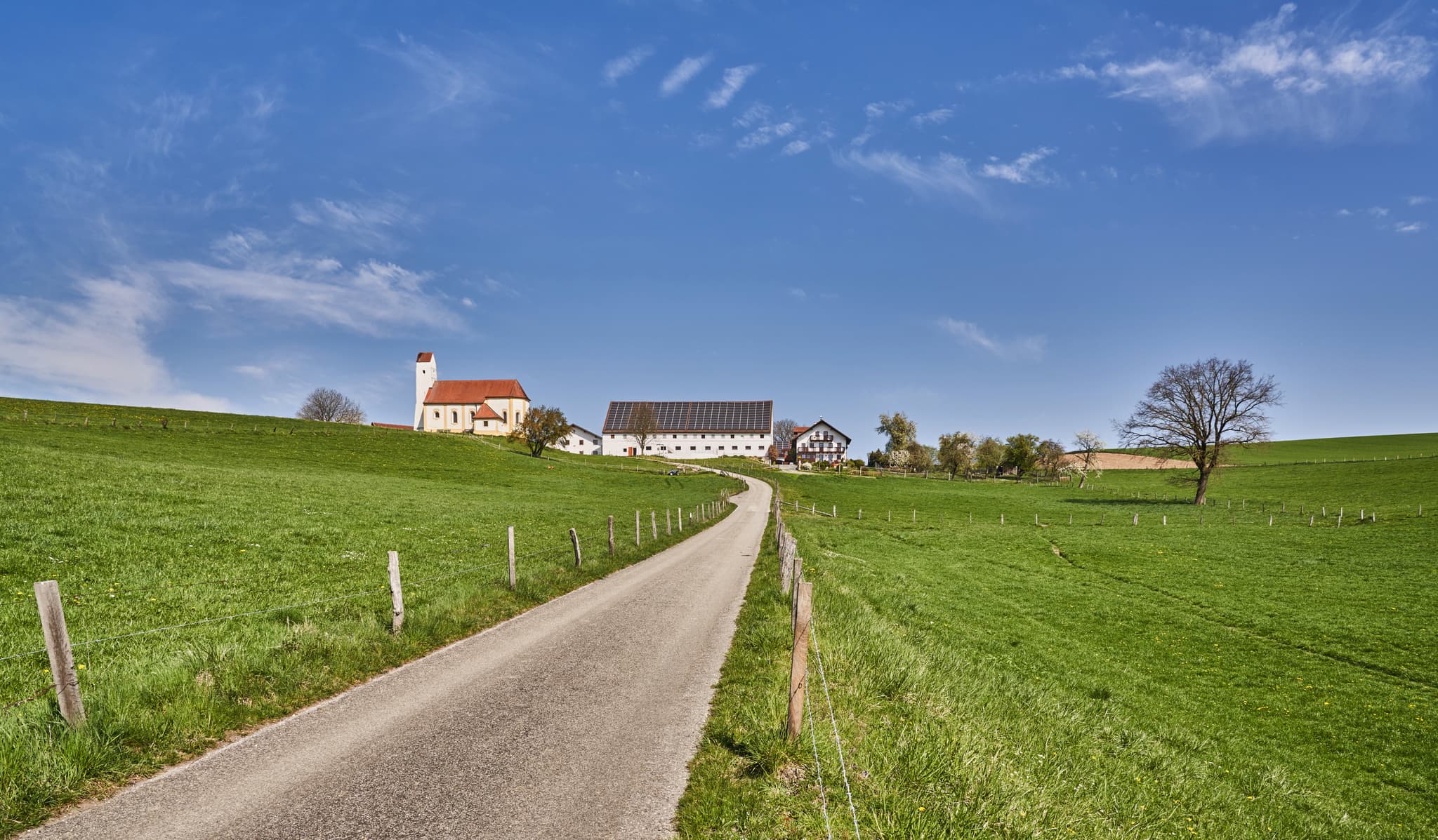 Idyllische Kirche Sankt Pankratius in Mettenheim, Mühldorf am Inn, Oberbayern, Region Inn-Salzach, Deutschland. Landschaftsbild mit Feldweg und Weitblick.